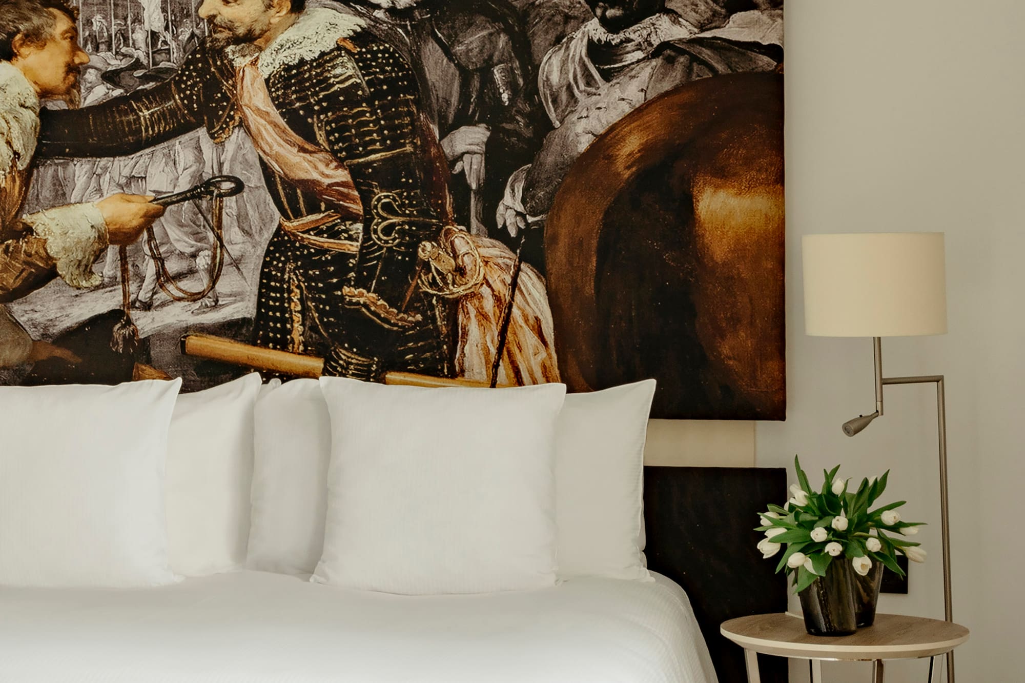 a bed with a painting on the wall