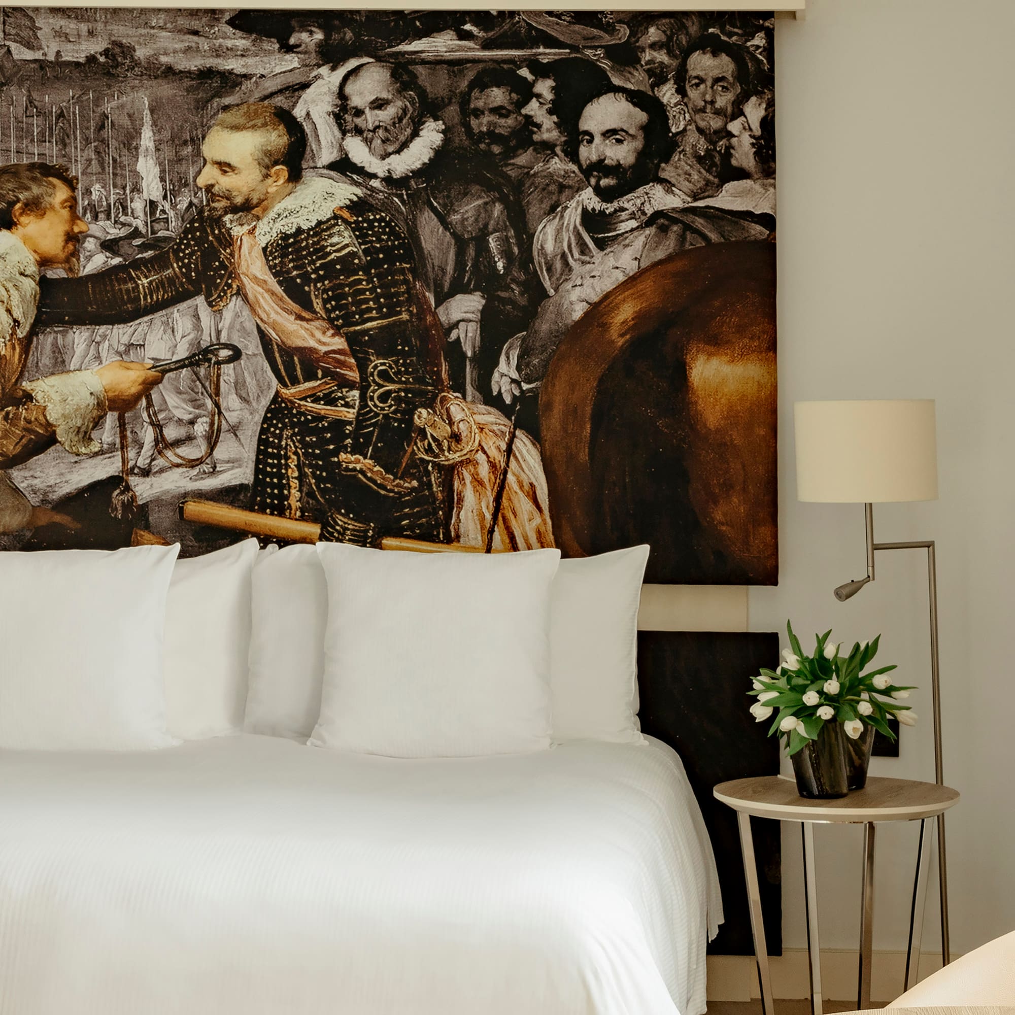 a bed with a painting on the wall