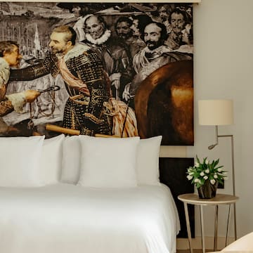 a bed with a painting on the wall