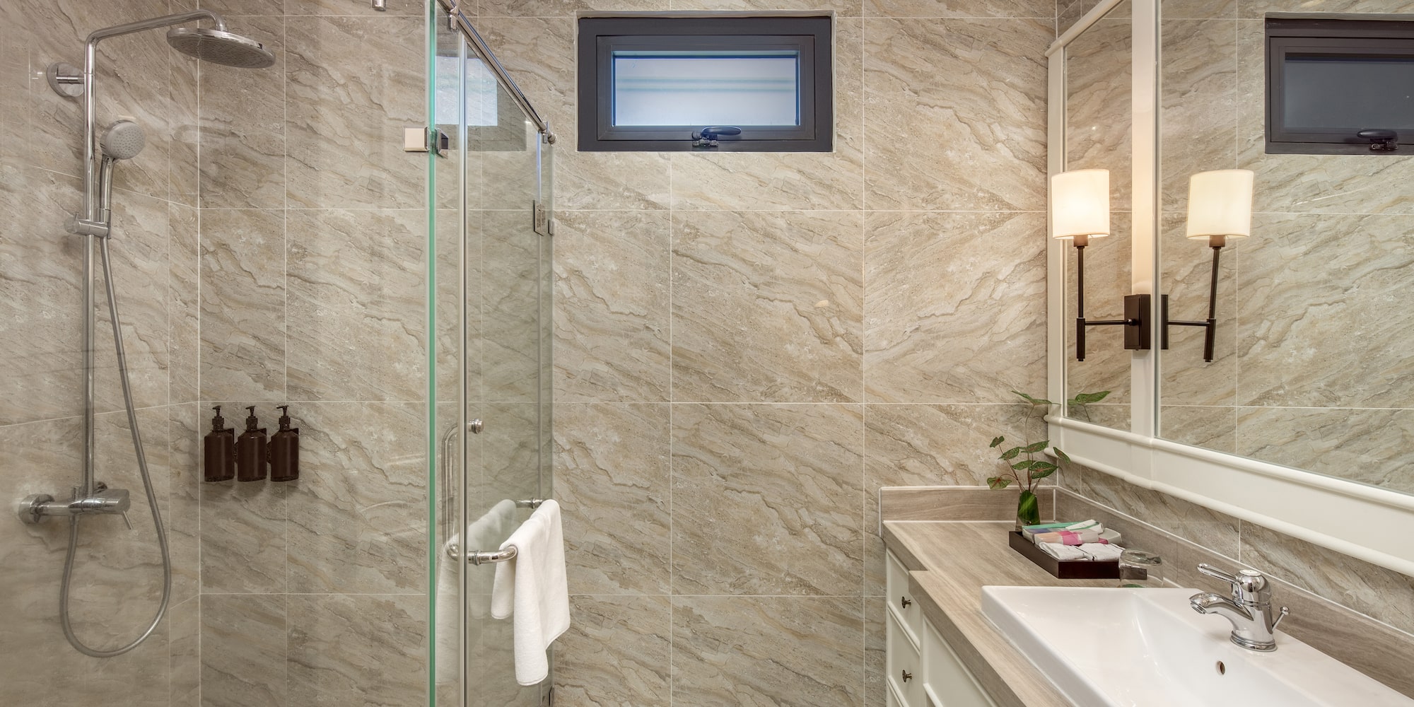 a bathroom with a glass shower and sink