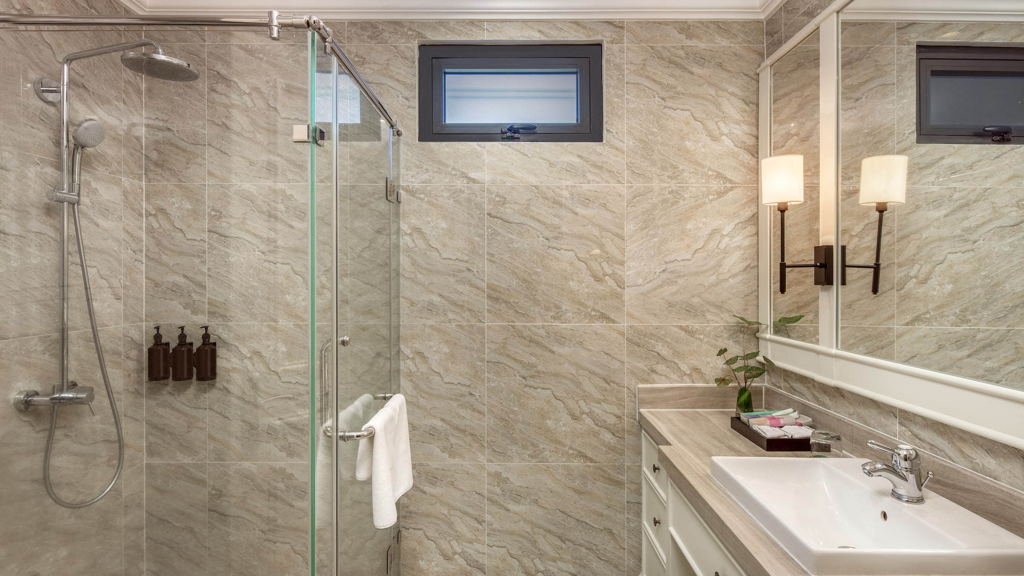 a bathroom with a glass shower and sink