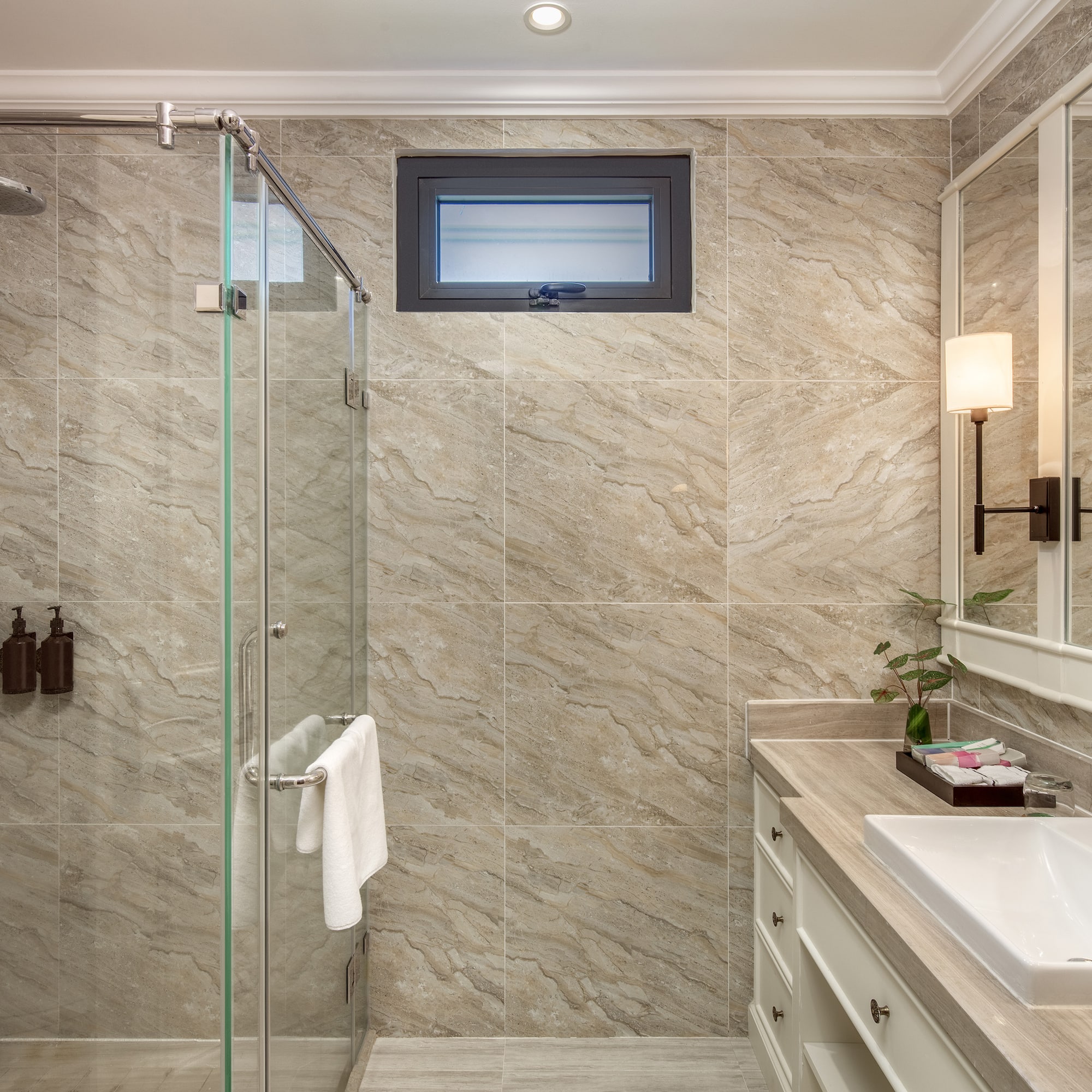 a bathroom with a glass shower and sink