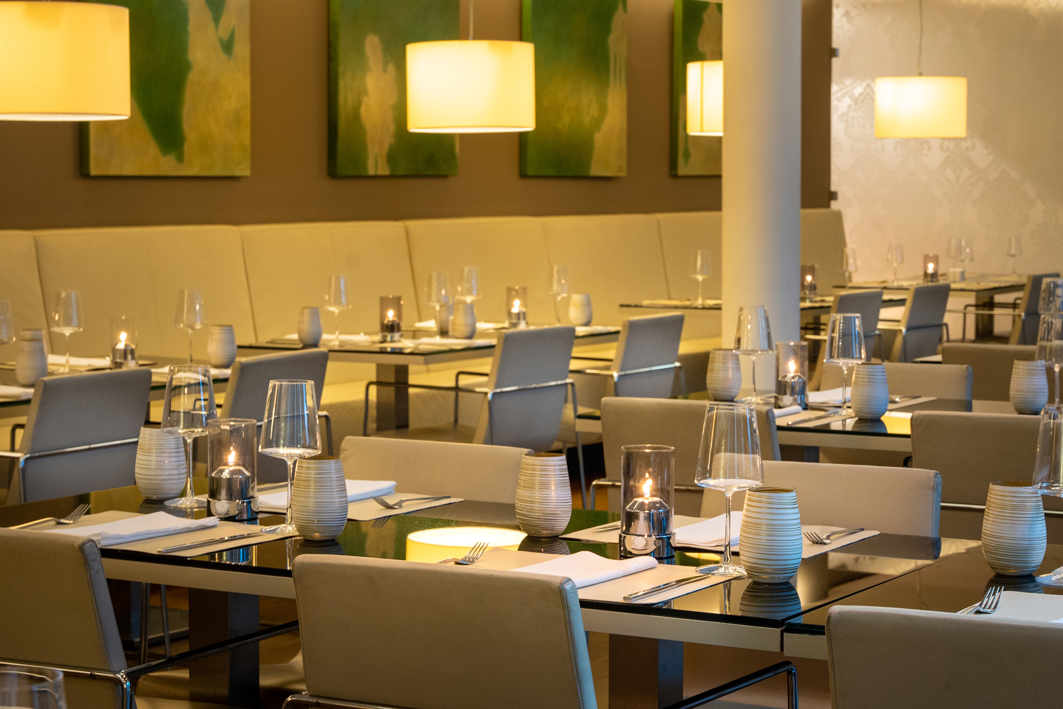 Elegant modern restaurant dining room with set tables and warm lighting.