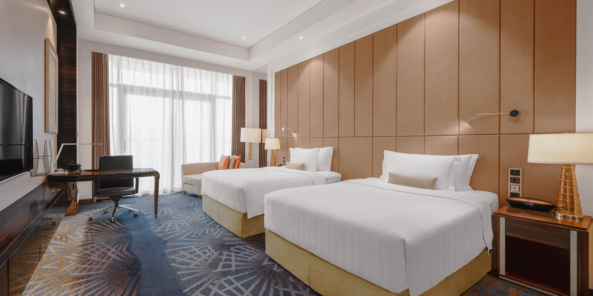 a room with two beds and a desk