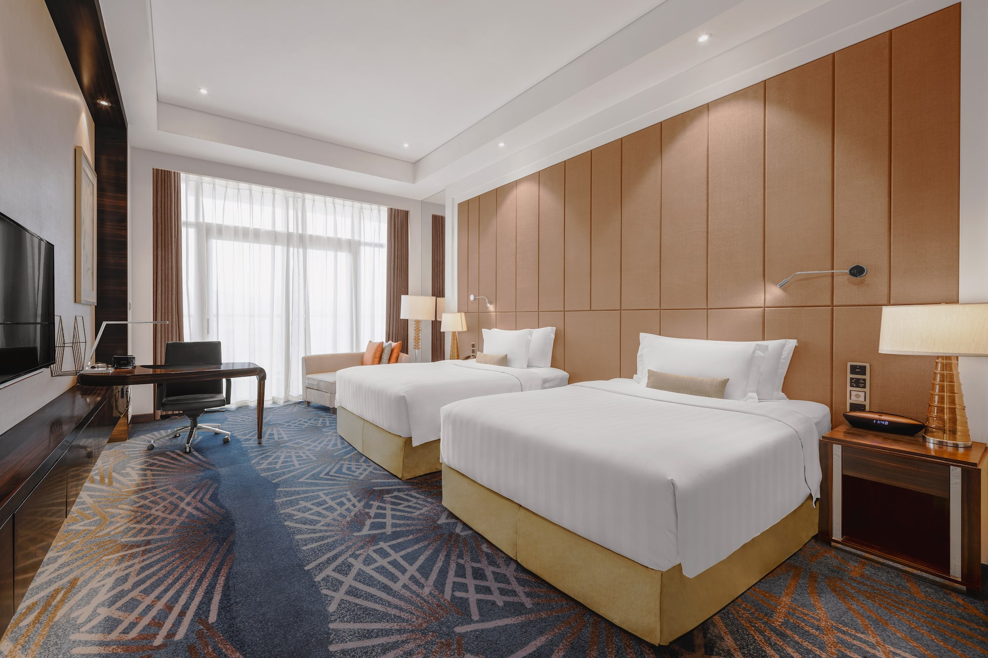 a room with two beds and a desk