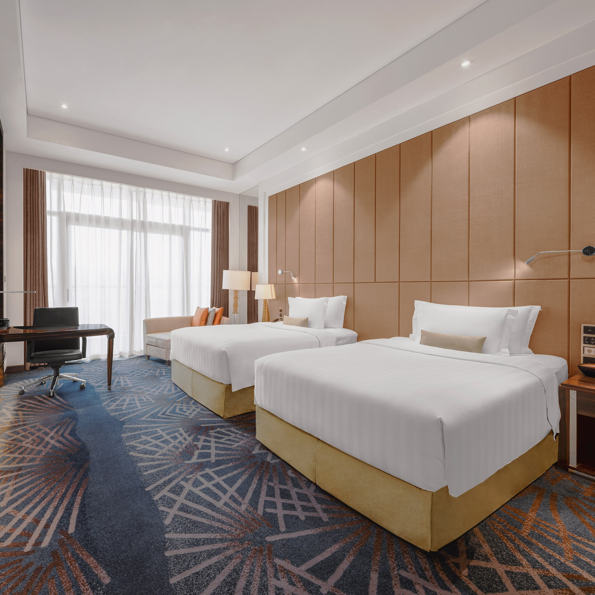 a room with two beds and a desk