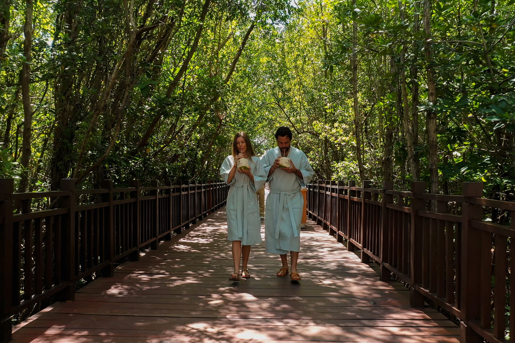 a man and woman in robes walking on a bridge