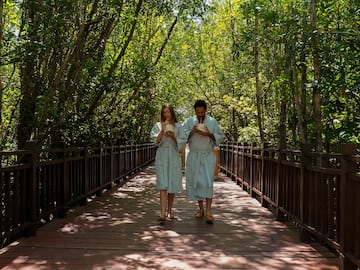 a man and woman in robes walking on a bridge