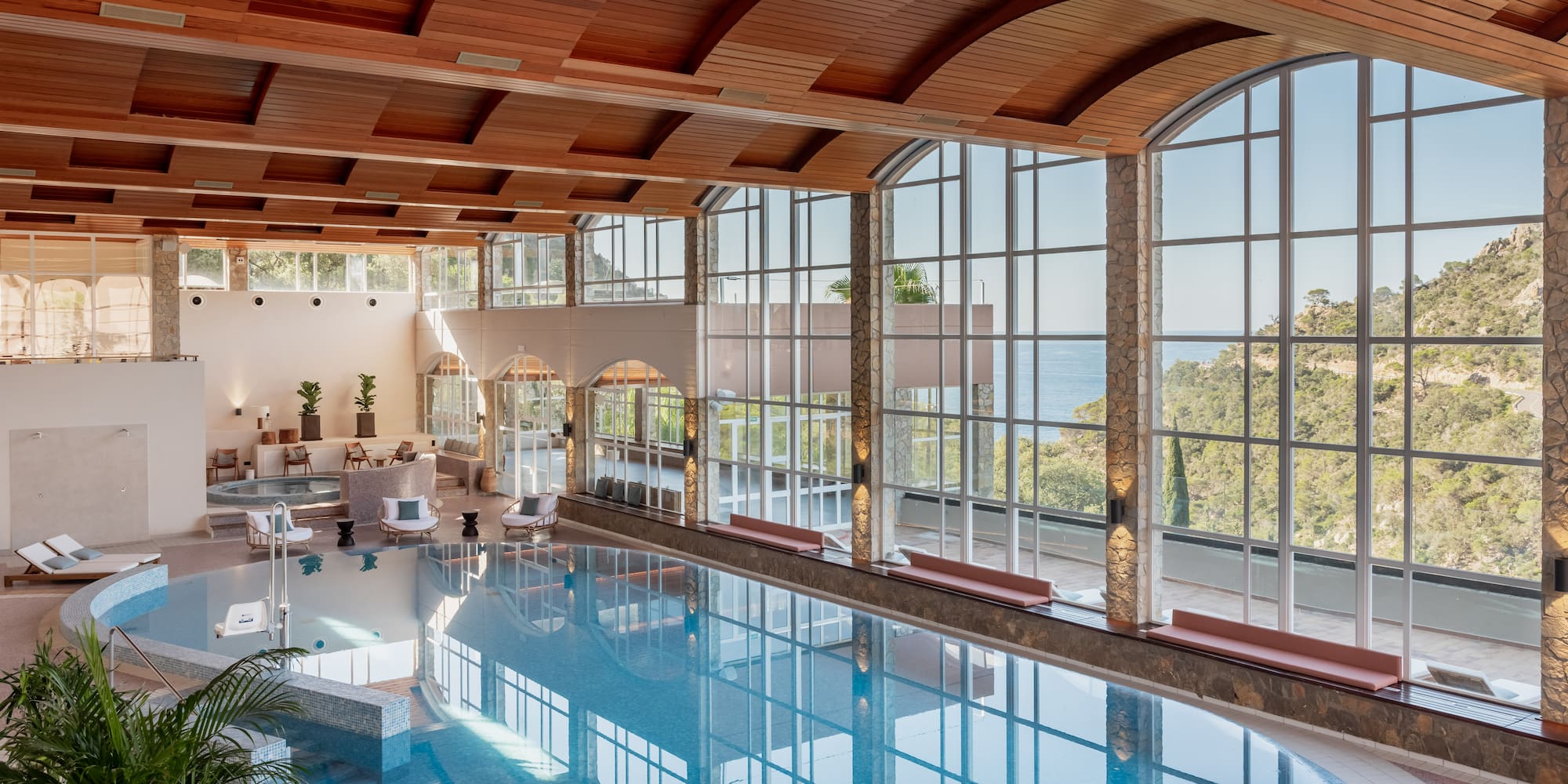 a indoor pool with a large glass wall and a large window