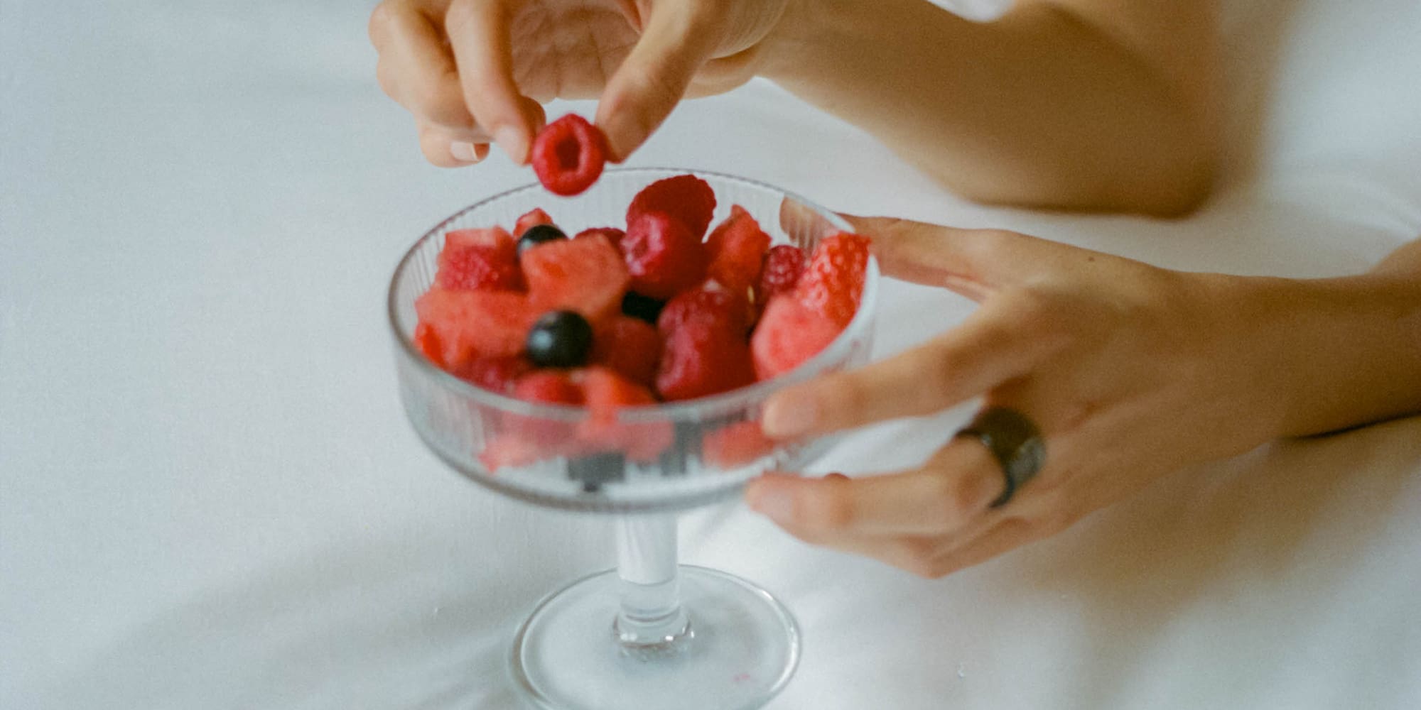 a person eating fruit in a bowl