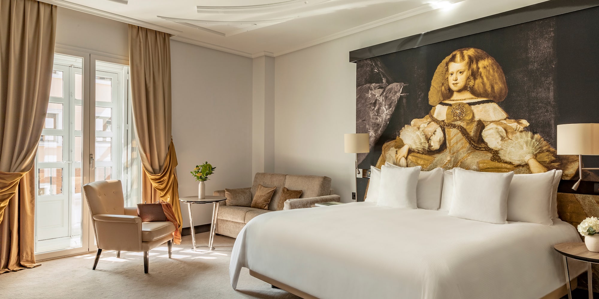 a room with a bed and chairs