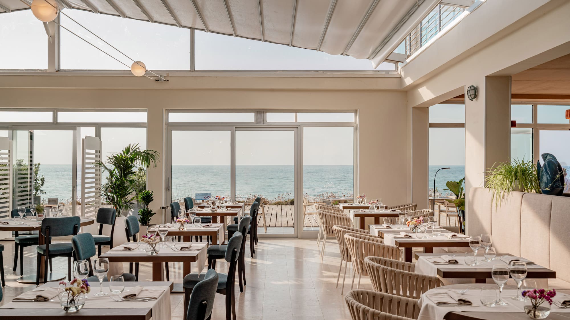 a room with tables and chairs and a large window