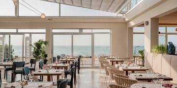 a room with tables and chairs and a large window