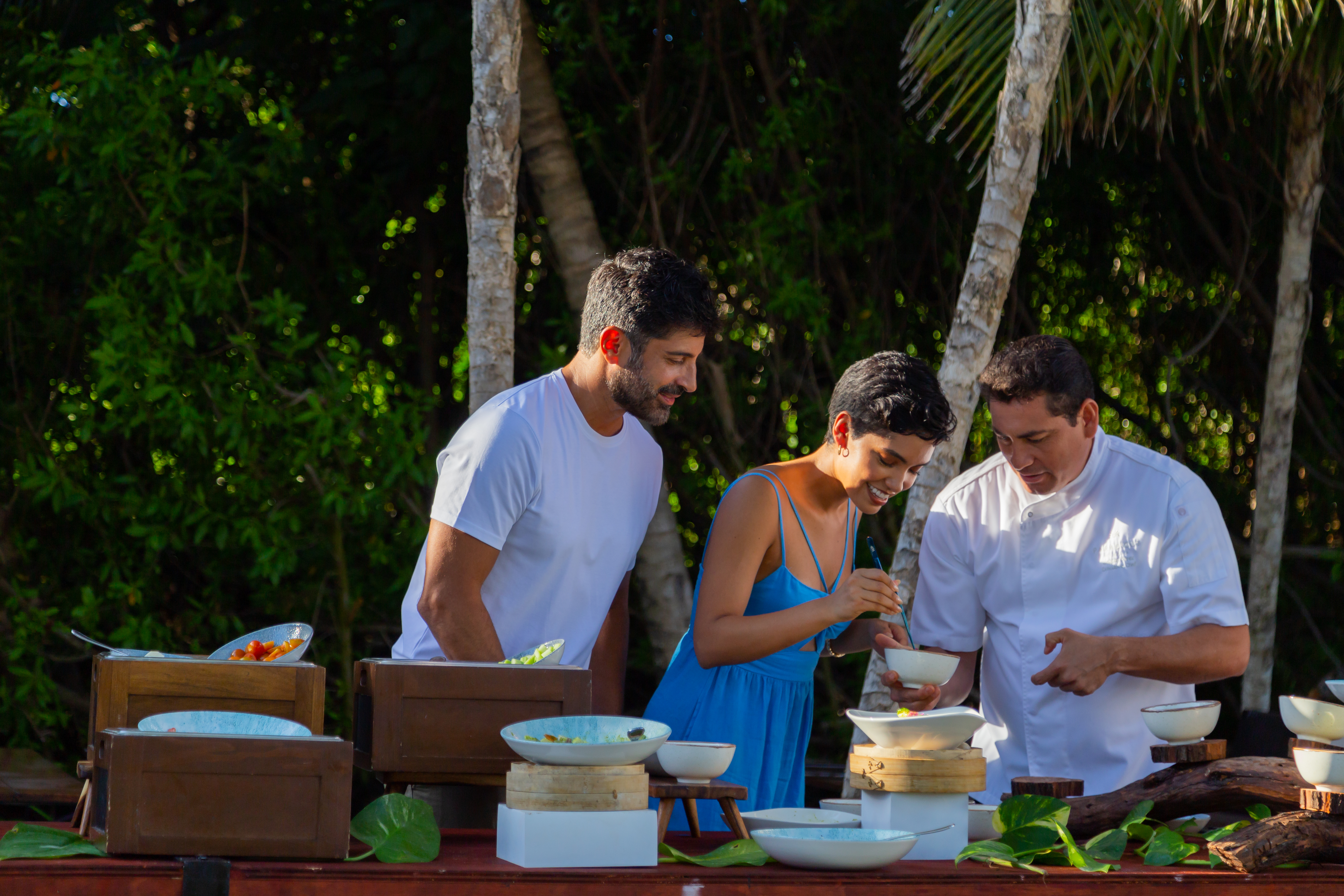 a group of people standing around a table with food