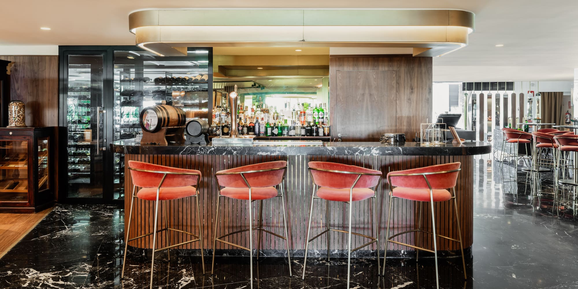 a bar with red chairs and a black counter