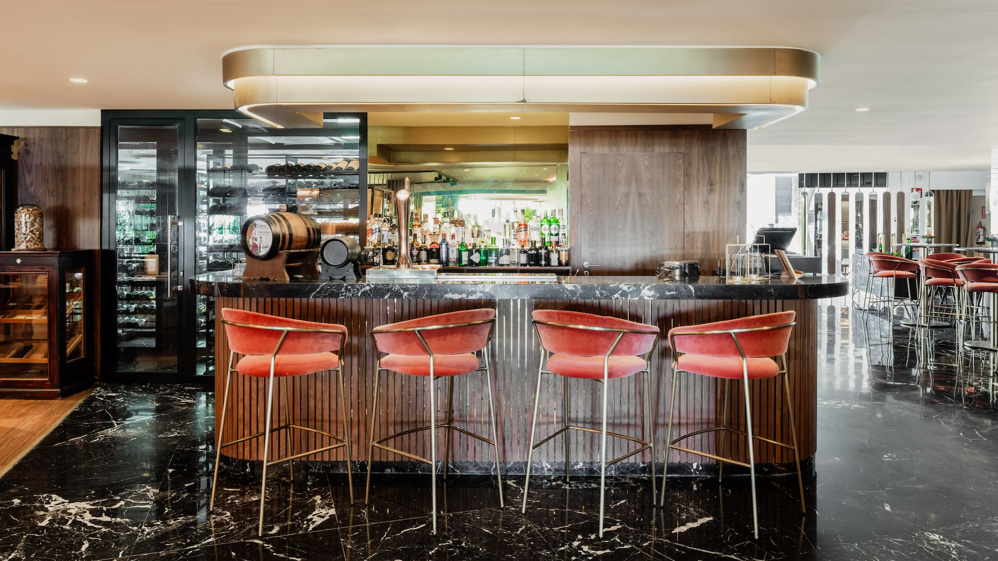 a bar with red chairs and a black counter