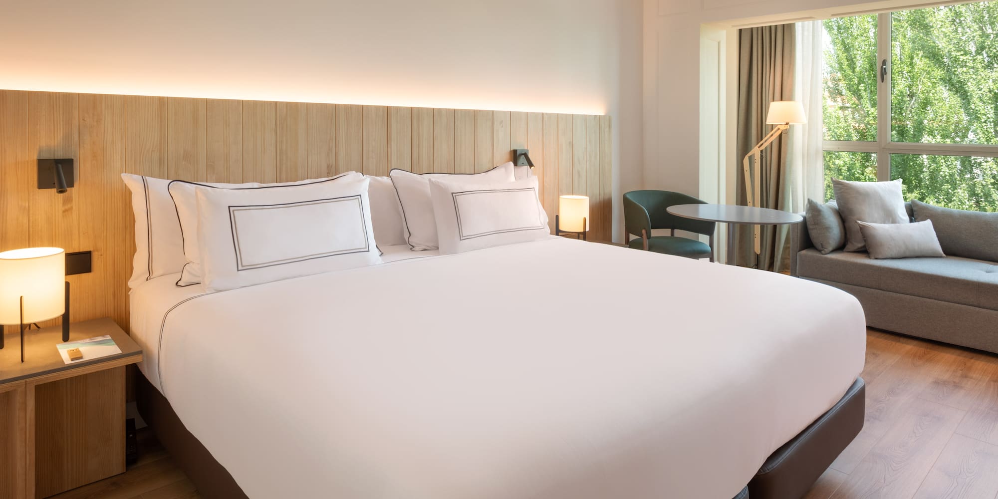 a bed with white sheets and a table and chairs