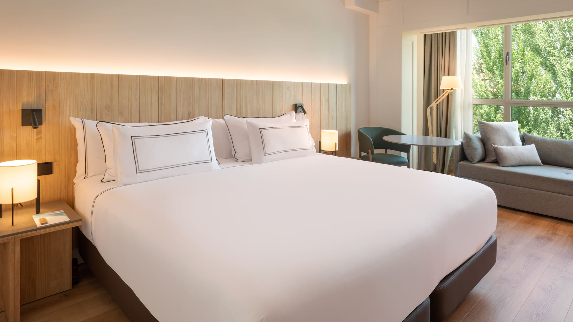 a bed with white sheets and a table and chairs