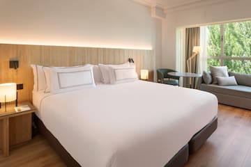 a bed with white sheets and a table and chairs