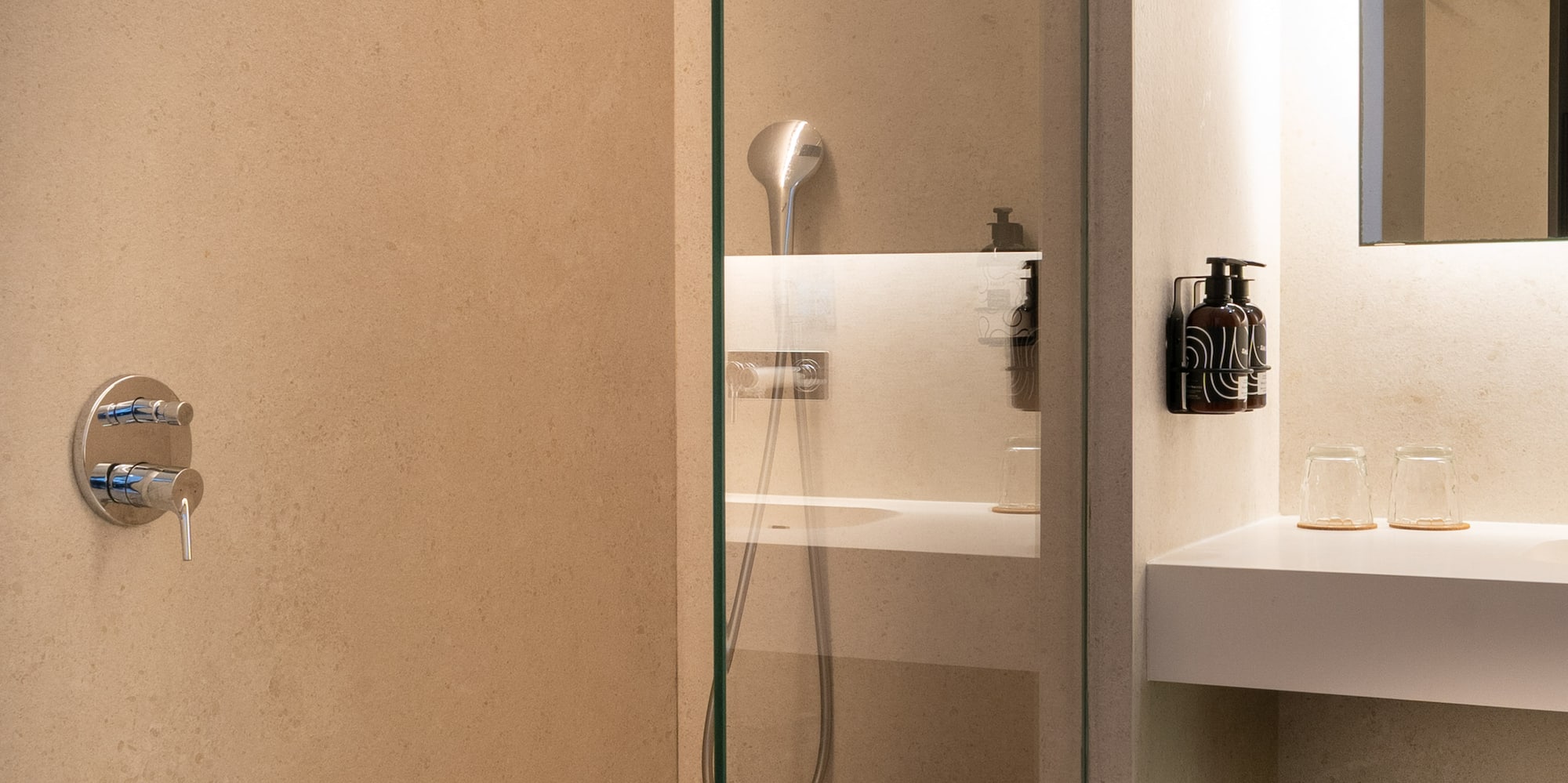 a glass shower with a sink and a mirror