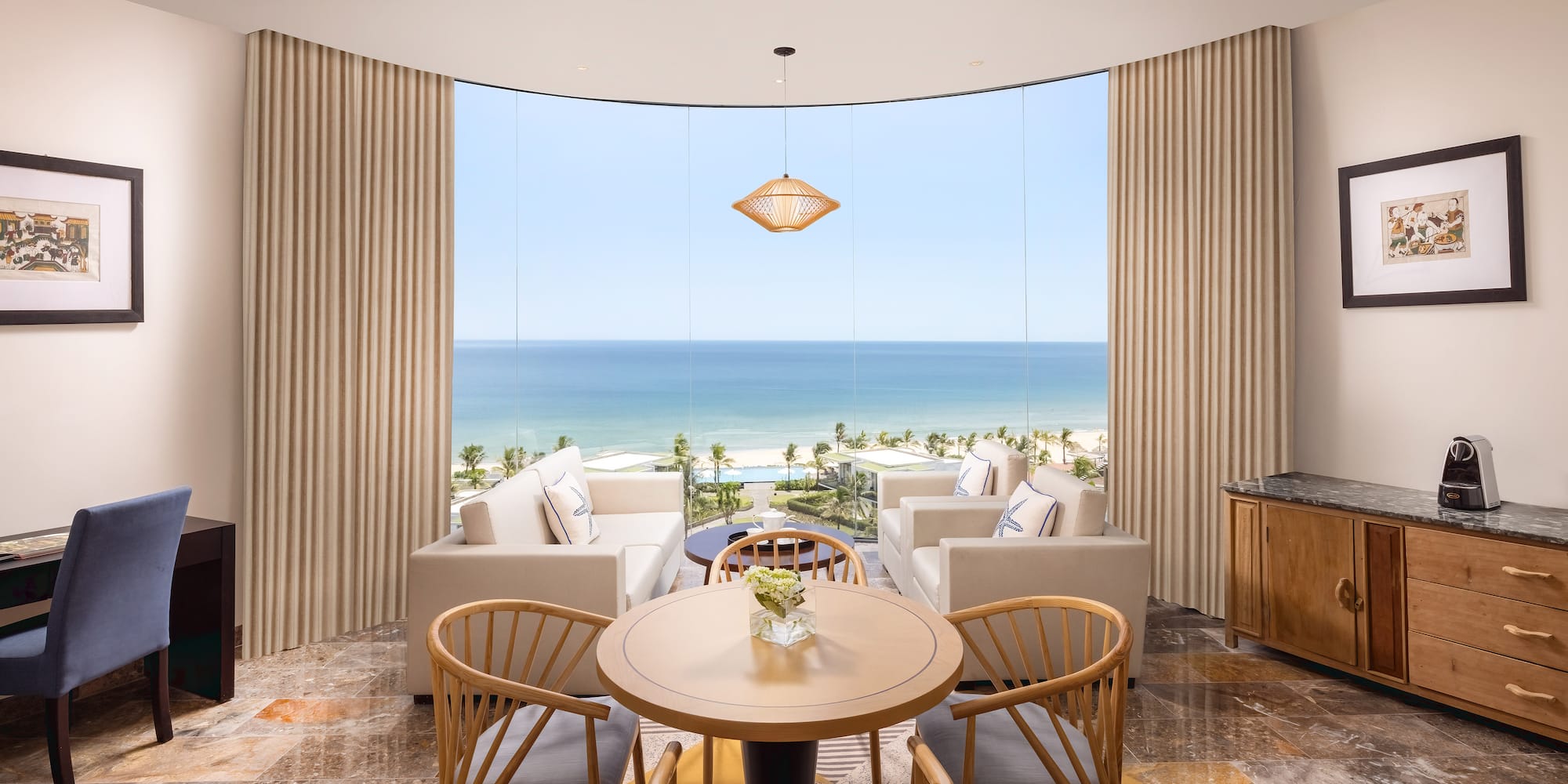 a room with a table and chairs and a view of the ocean
