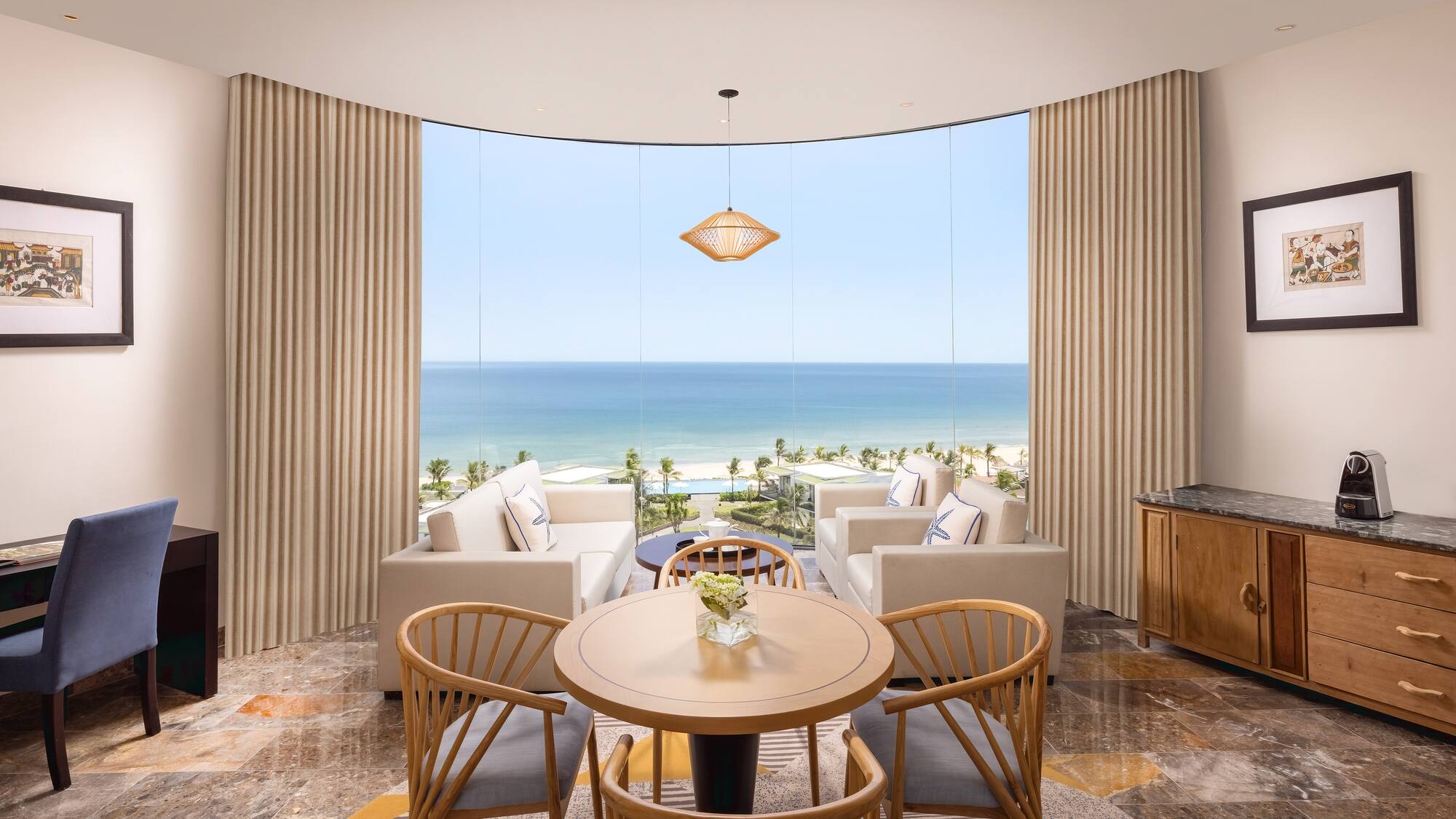 a room with a table and chairs and a view of the ocean