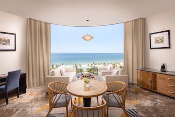 a room with a table and chairs and a view of the ocean