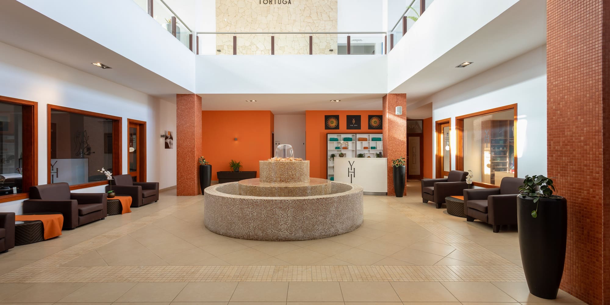 a large room with a fountain and chairs