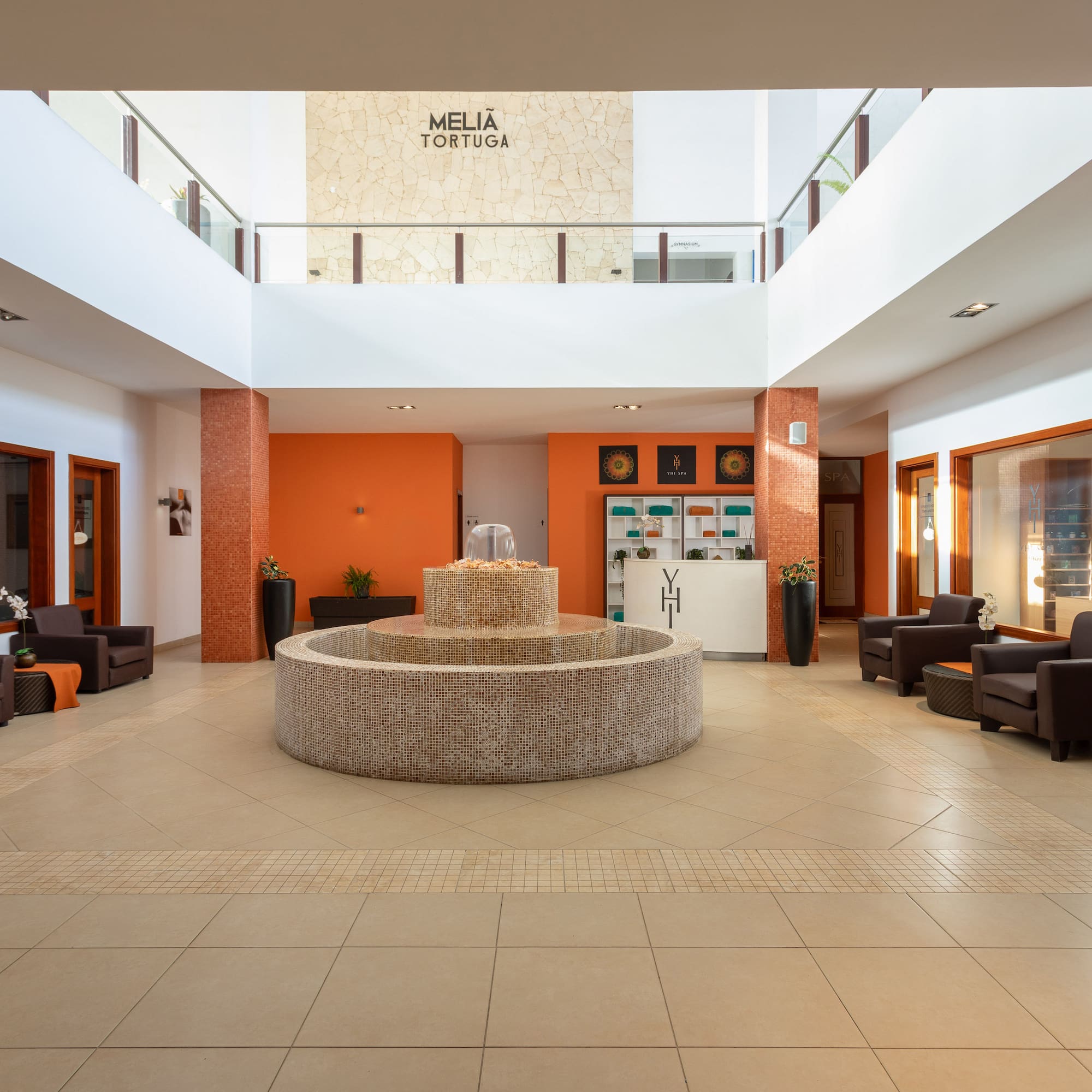 a large room with a fountain and chairs