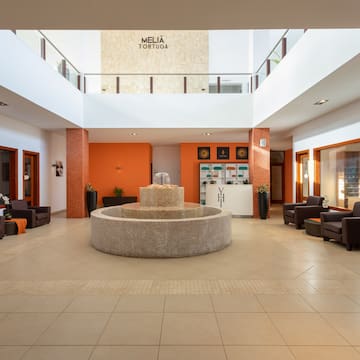 a large room with a fountain and chairs