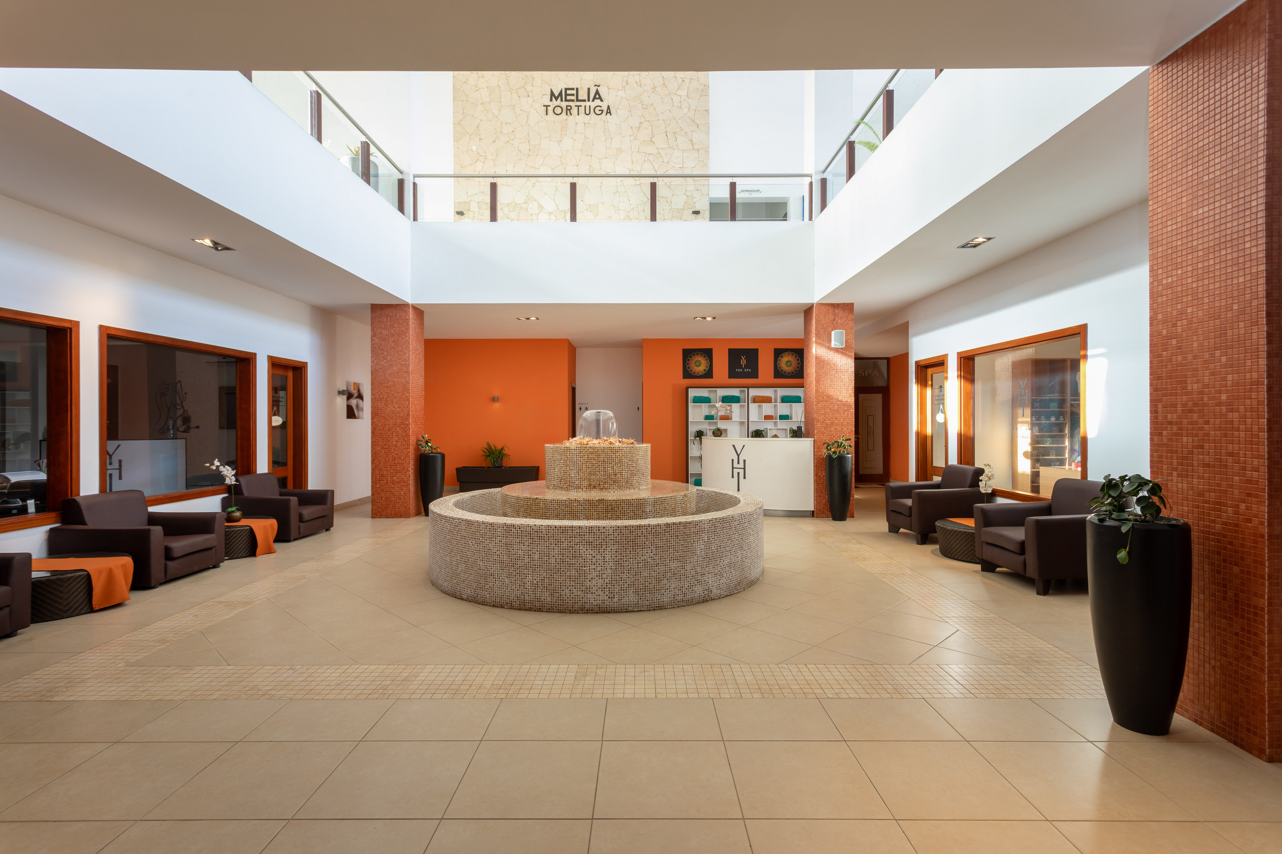 a large room with a fountain and chairs