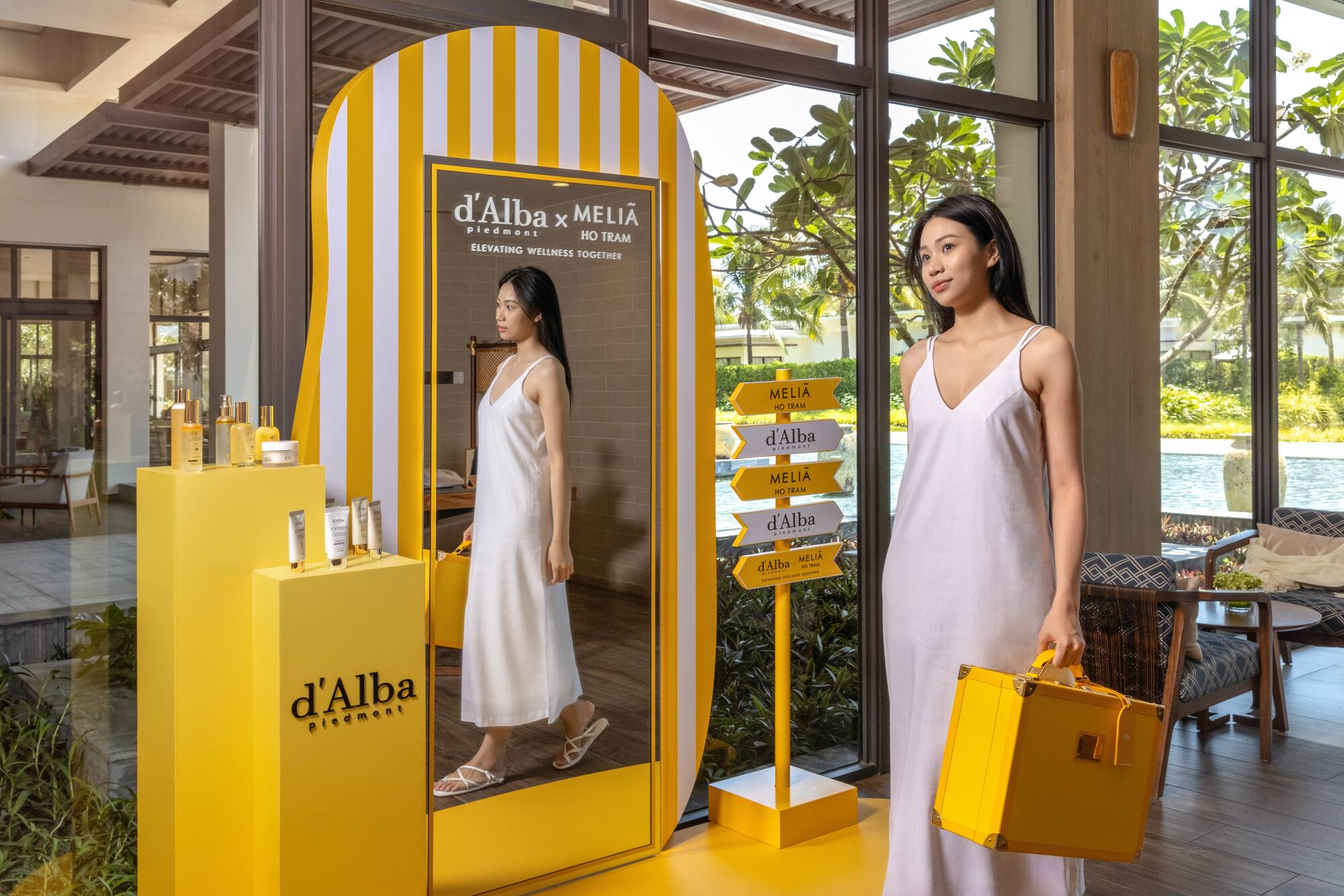 d'Alba x Meliã Ho Tram wellness display with woman and skincare products.