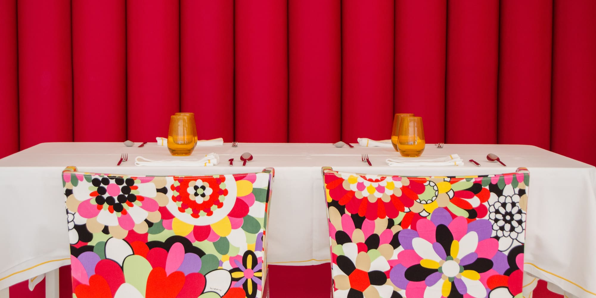 chairs with colorful chairs and a table with a red curtain