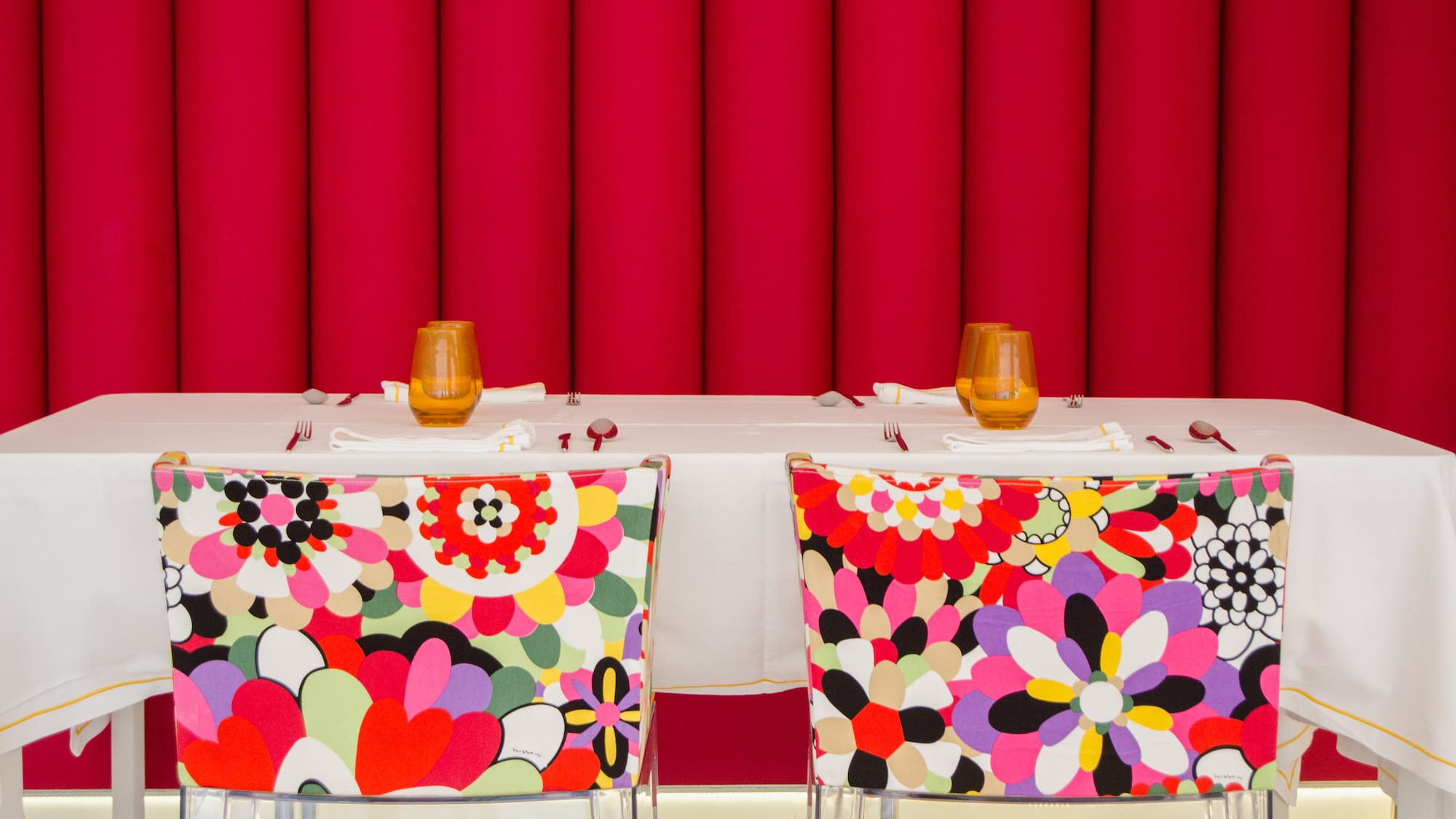 chairs with colorful chairs and a table with a red curtain