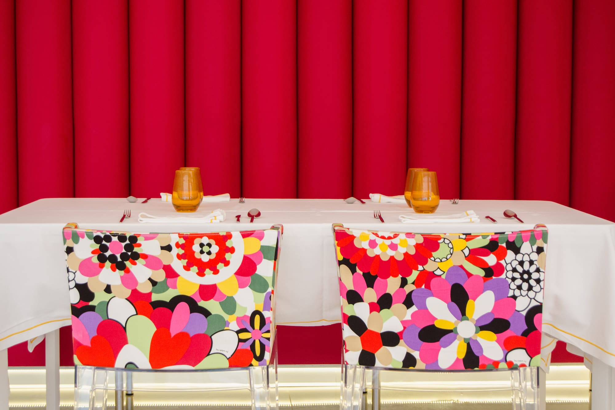 chairs with colorful chairs and a table with a red curtain
