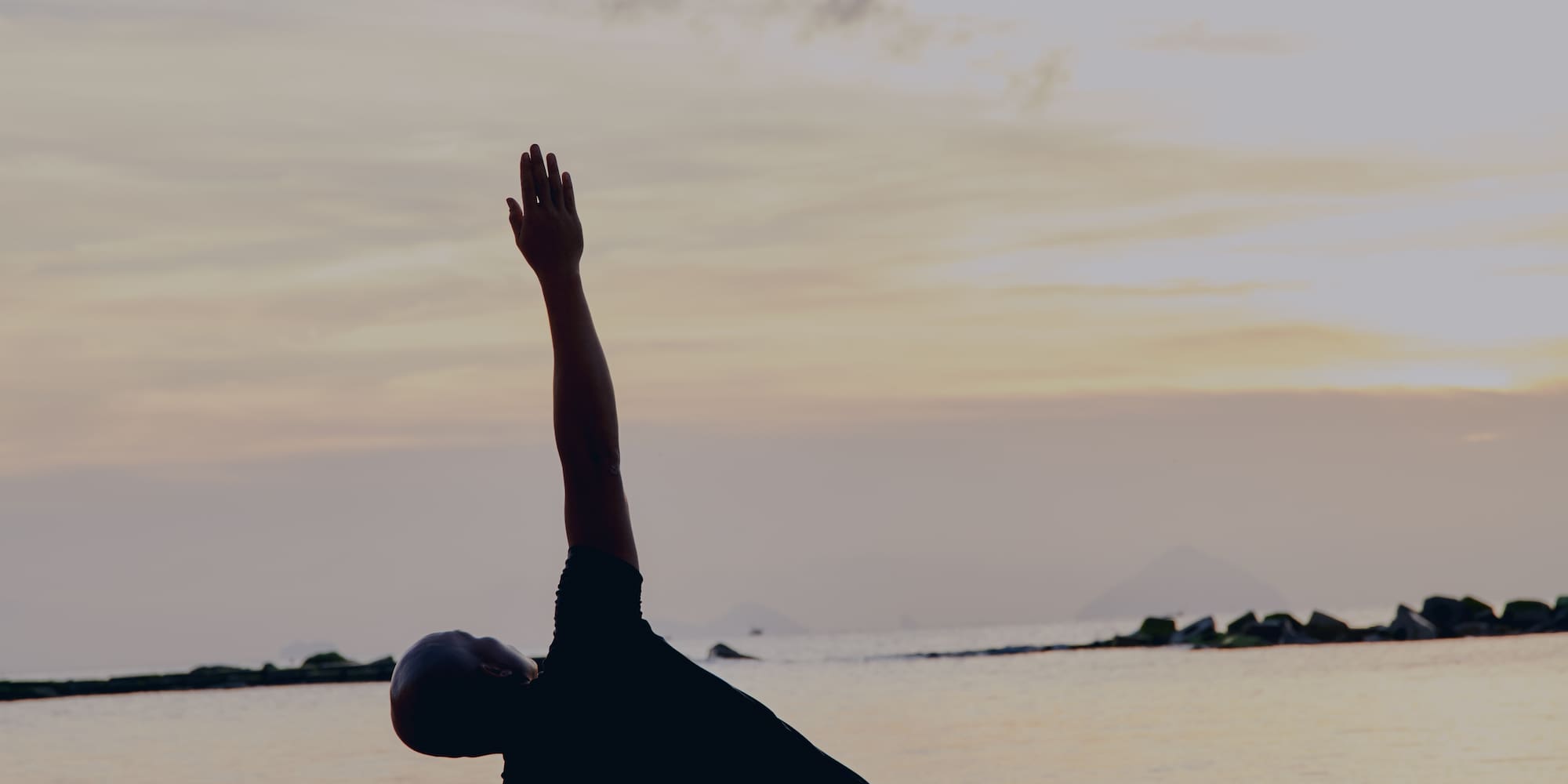 a man doing yoga on a beach