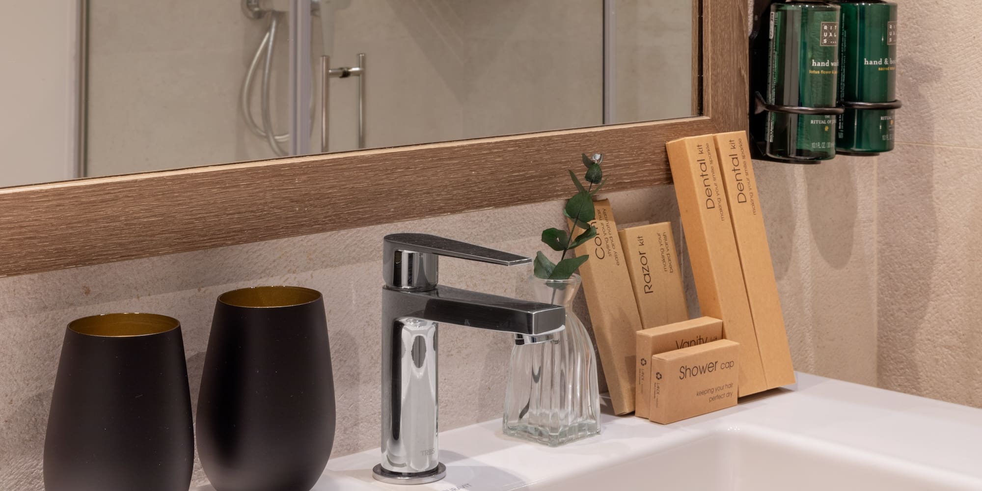 Hotel bathroom sink with modern faucet, toiletries, and Rituals hand wash.