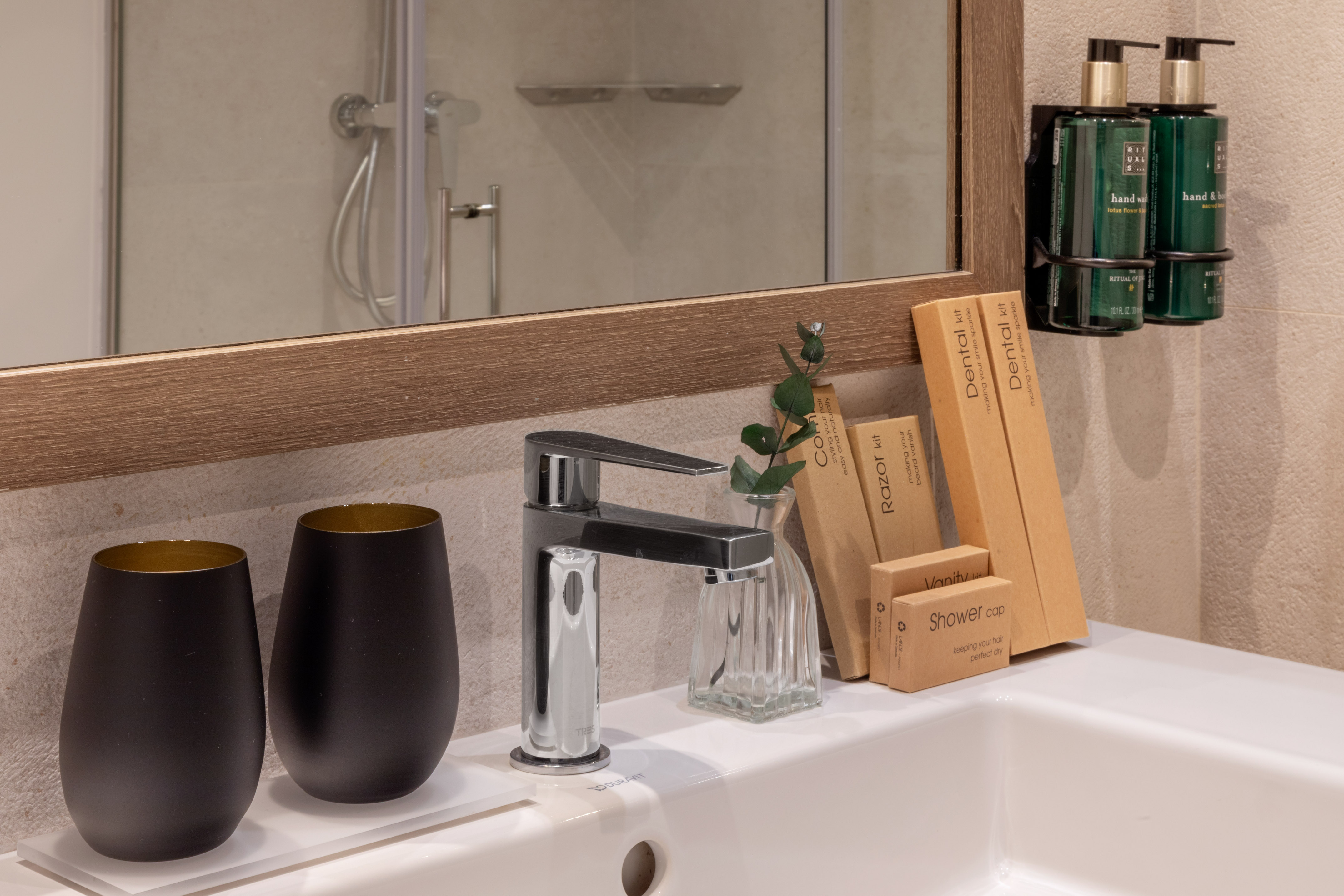 Hotel bathroom sink with modern faucet, toiletries, and Rituals hand wash.