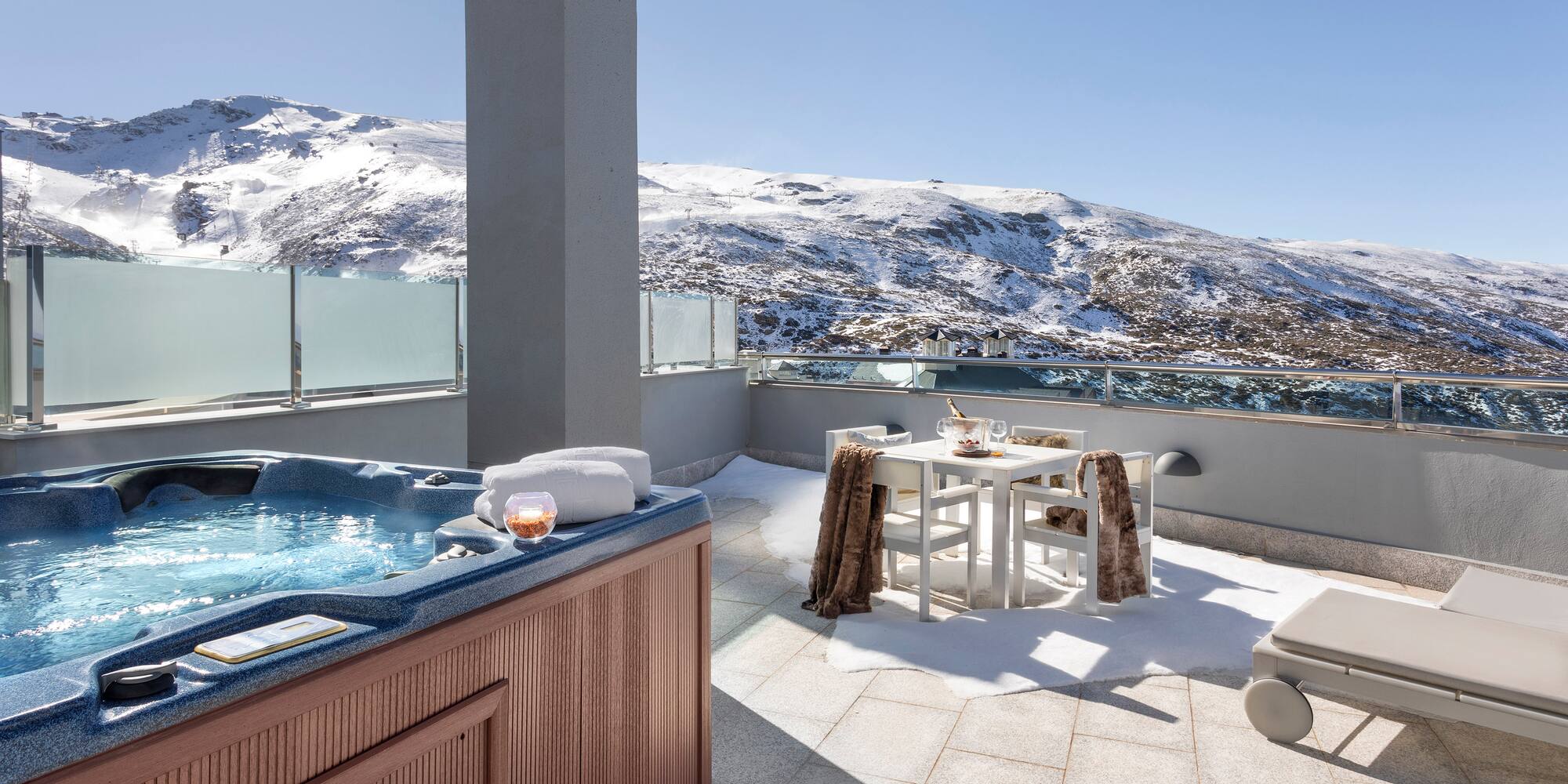 a hot tub on a rooftop with snow covered mountains in the background