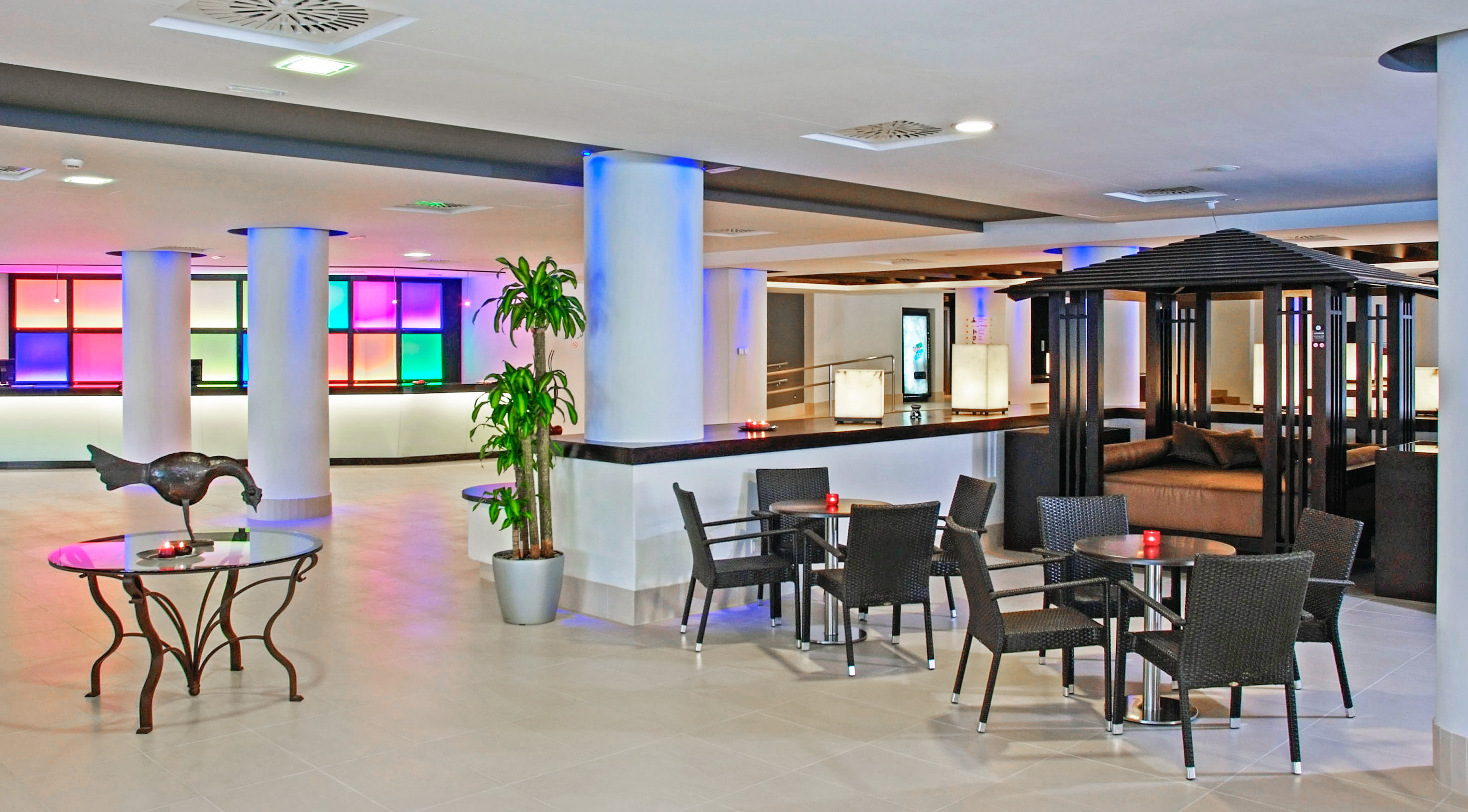 Vibrant hotel lounge, colorful reception, diverse seating, unique decor.