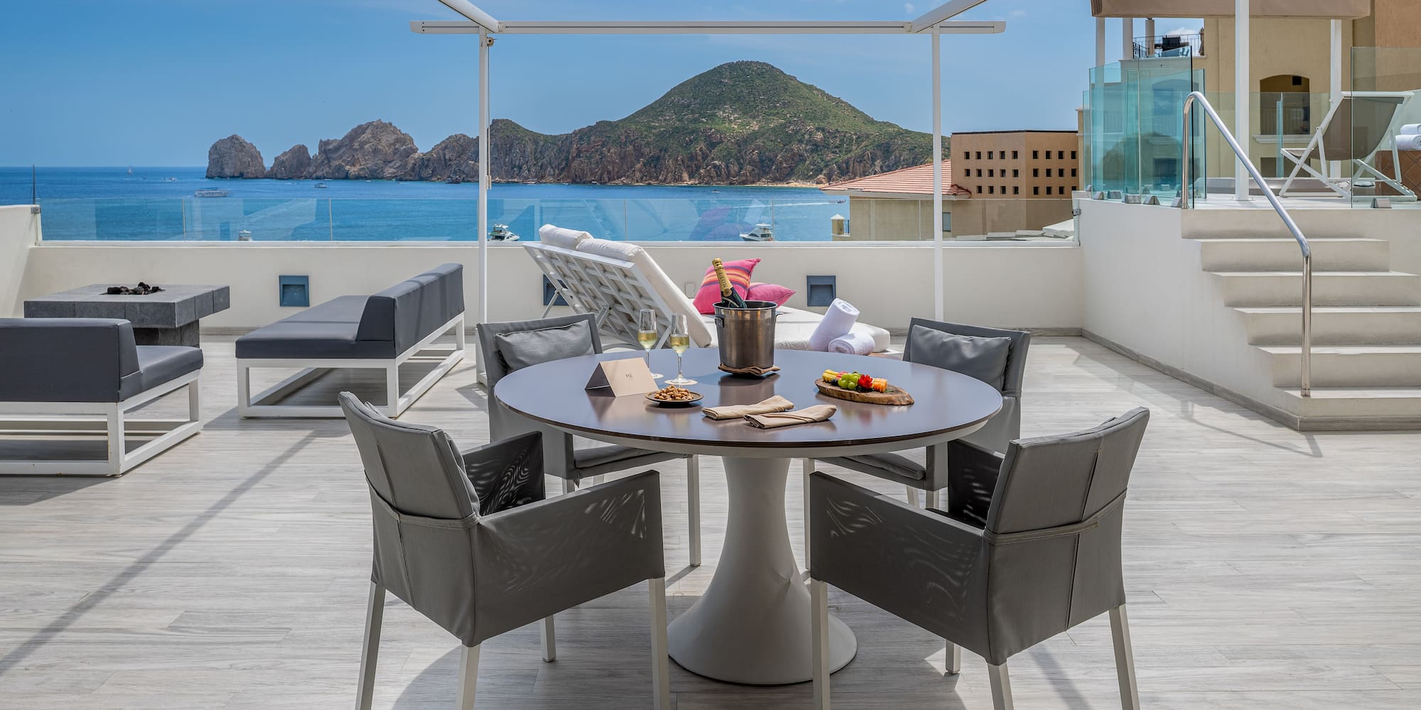 a table and chairs on a deck overlooking a body of water