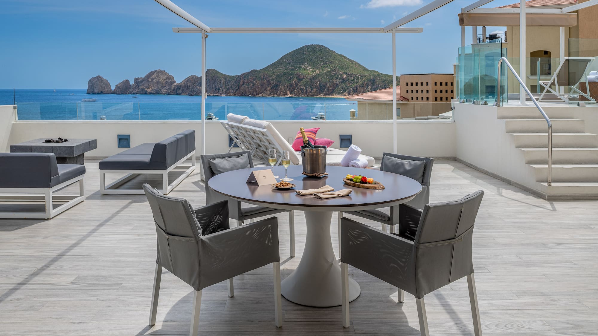 a table and chairs on a deck overlooking a body of water