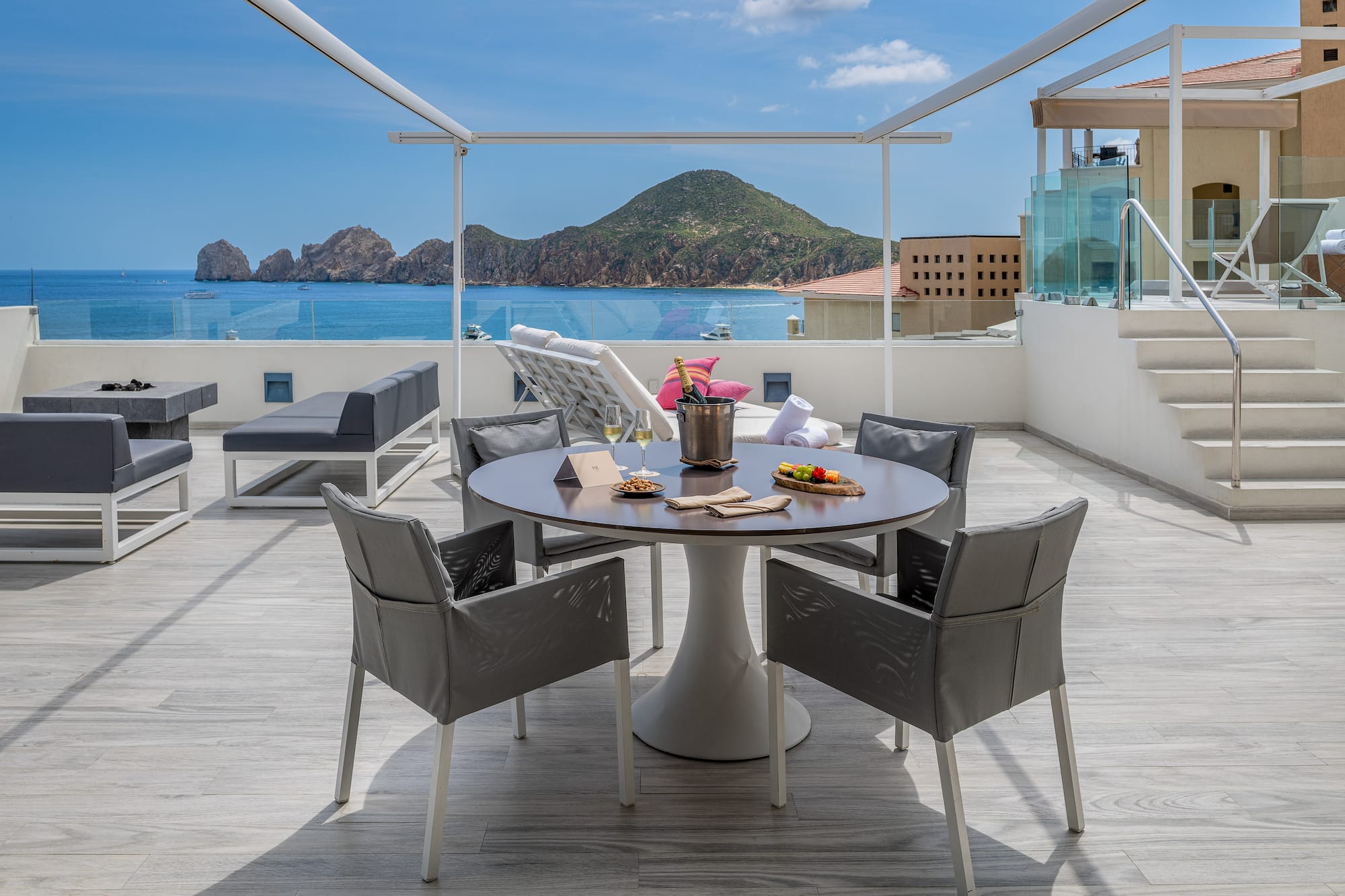 a table and chairs on a deck overlooking a body of water