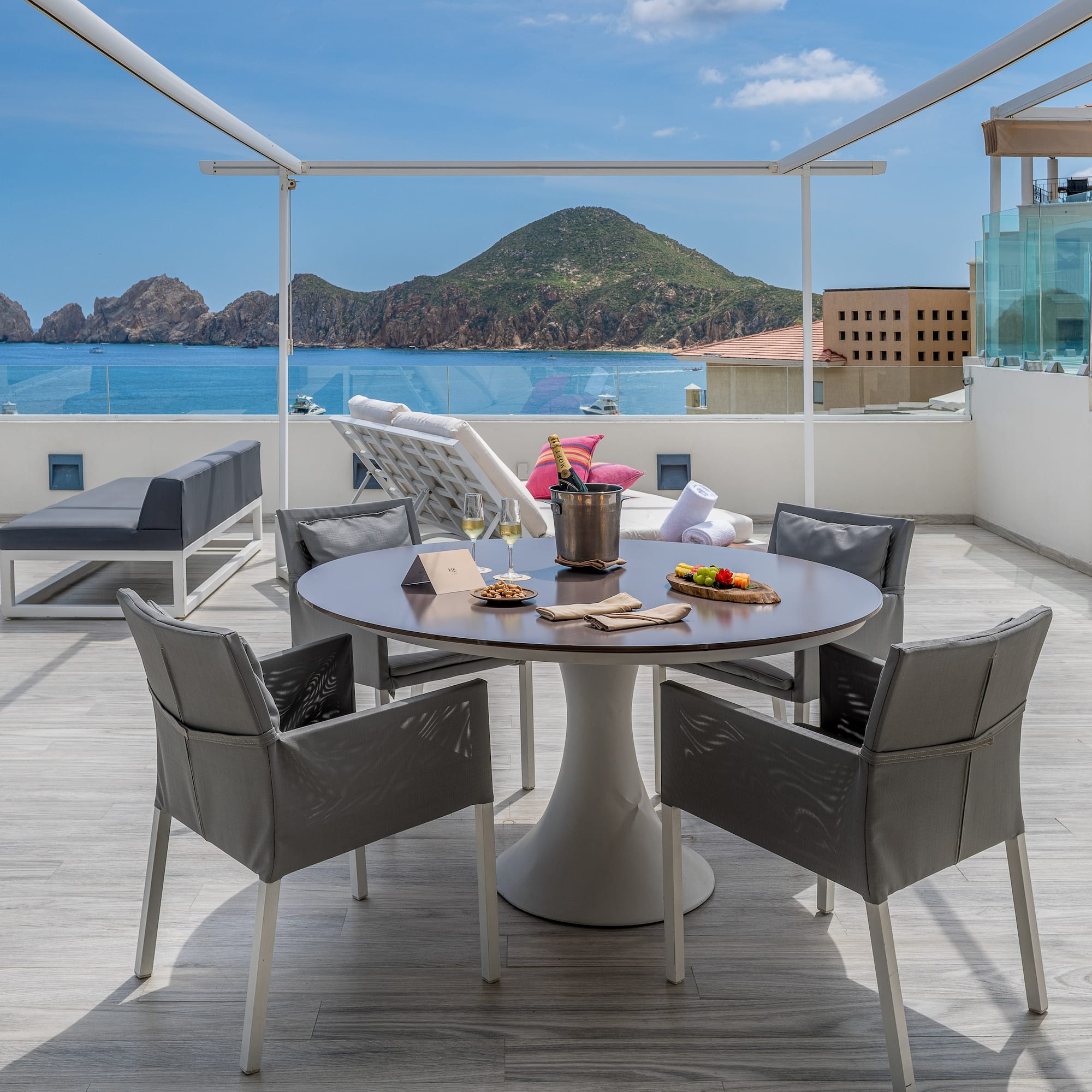 a table and chairs on a deck overlooking a body of water