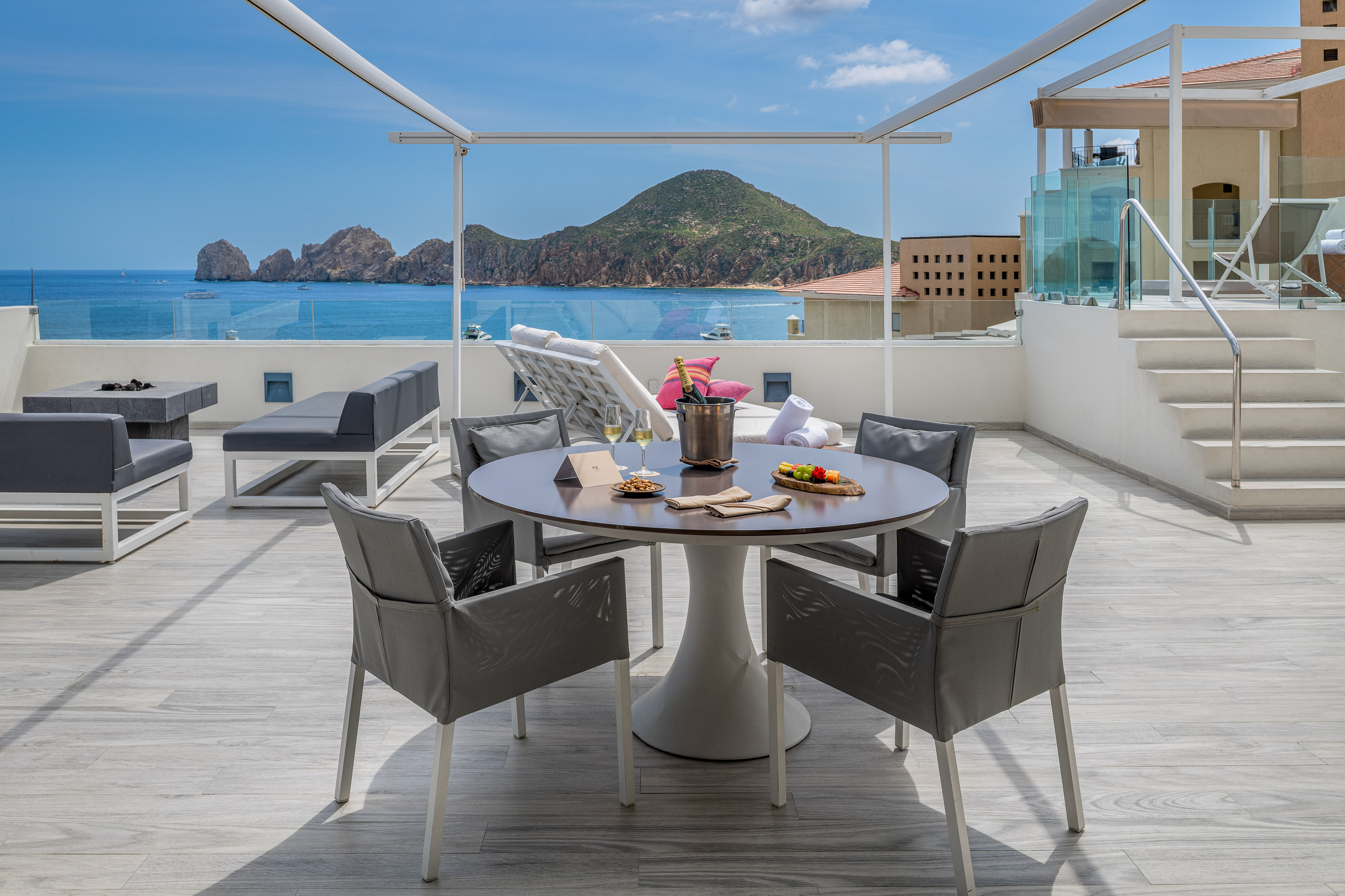 a table and chairs on a deck overlooking a body of water