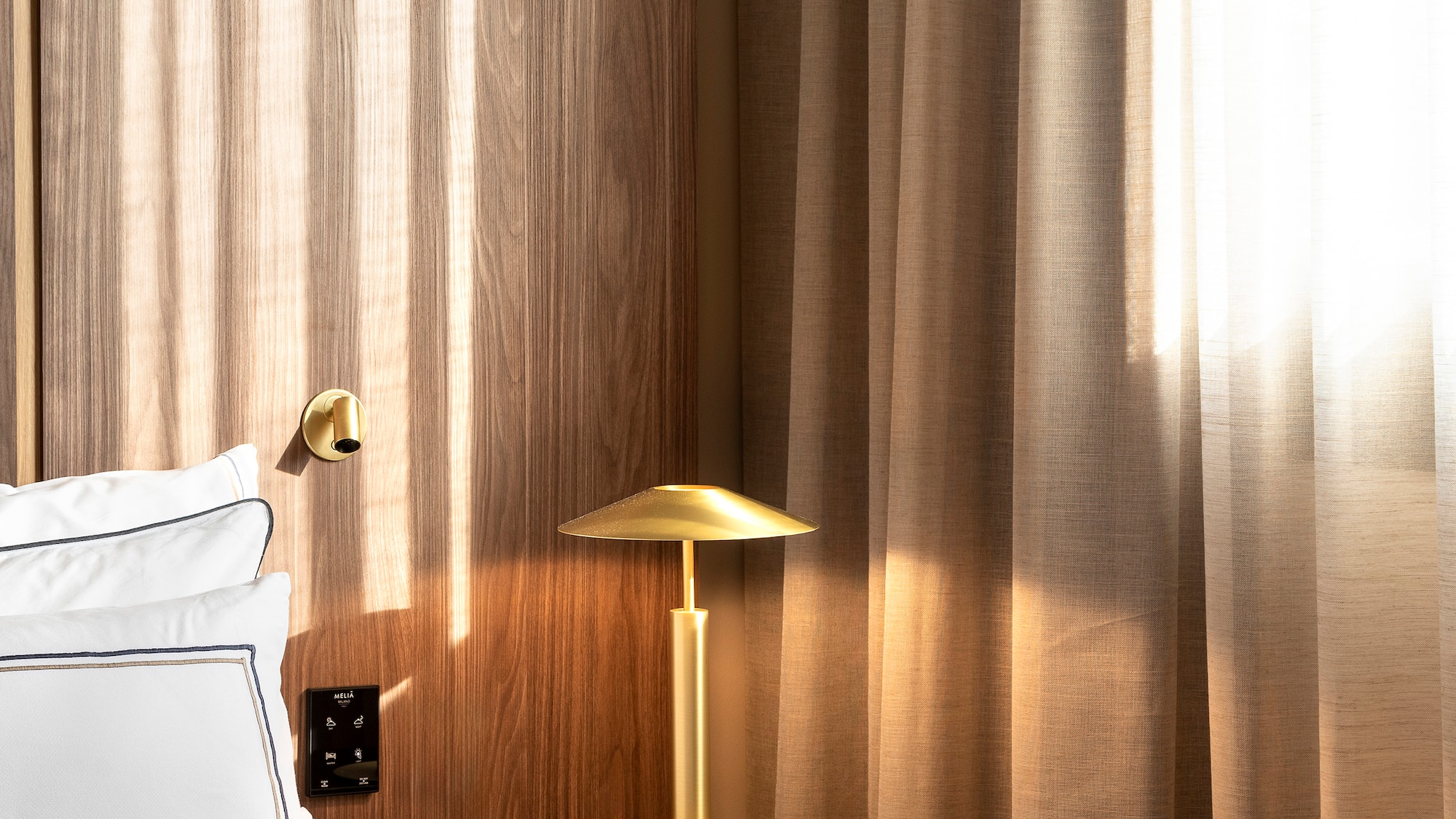 a bed with a lamp on a table