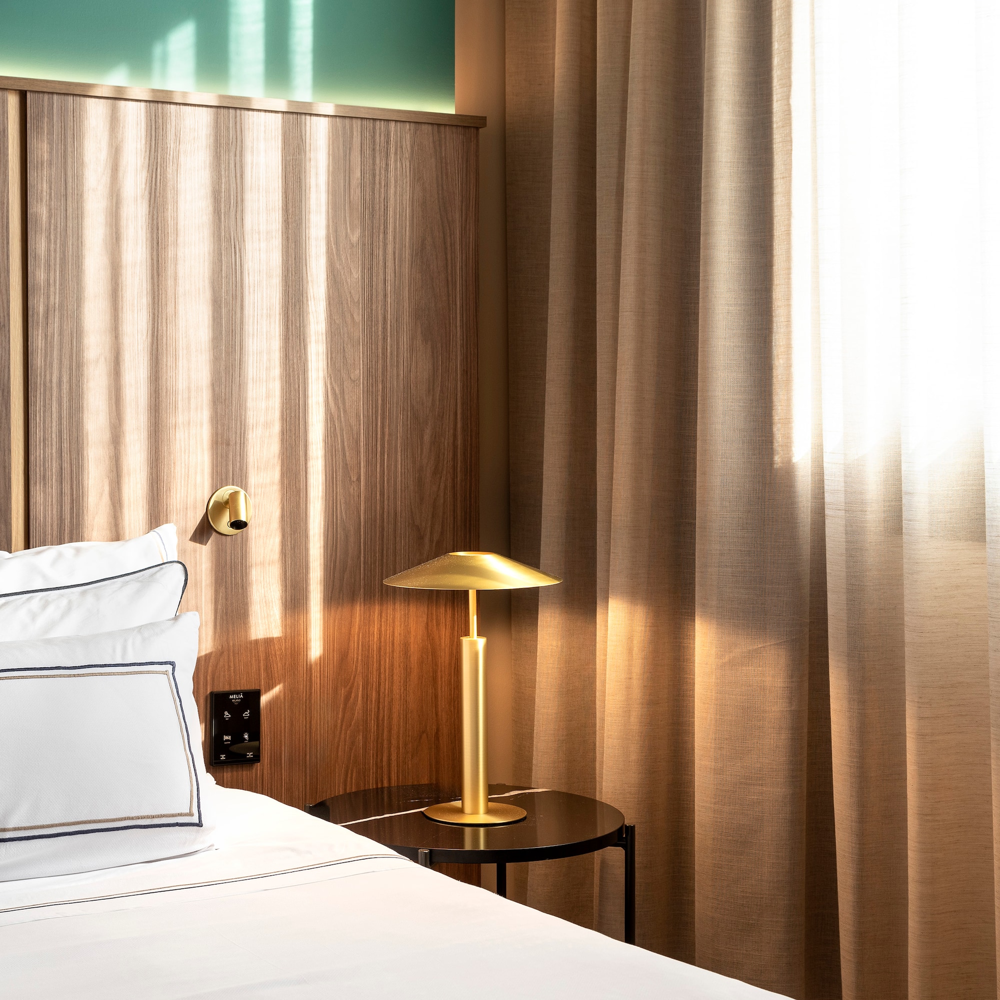 a bed with a lamp on a table