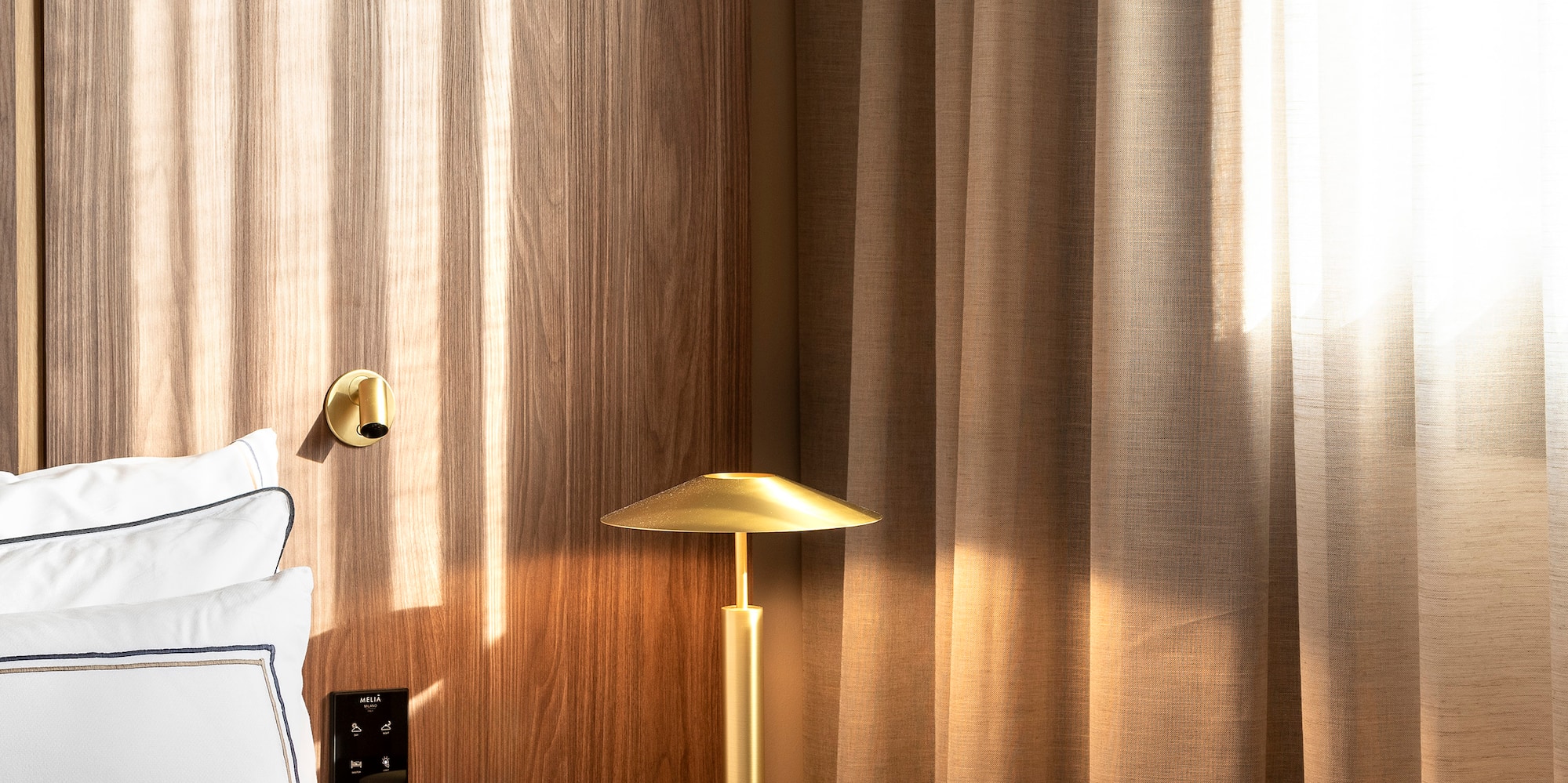 a bed with a lamp on a table