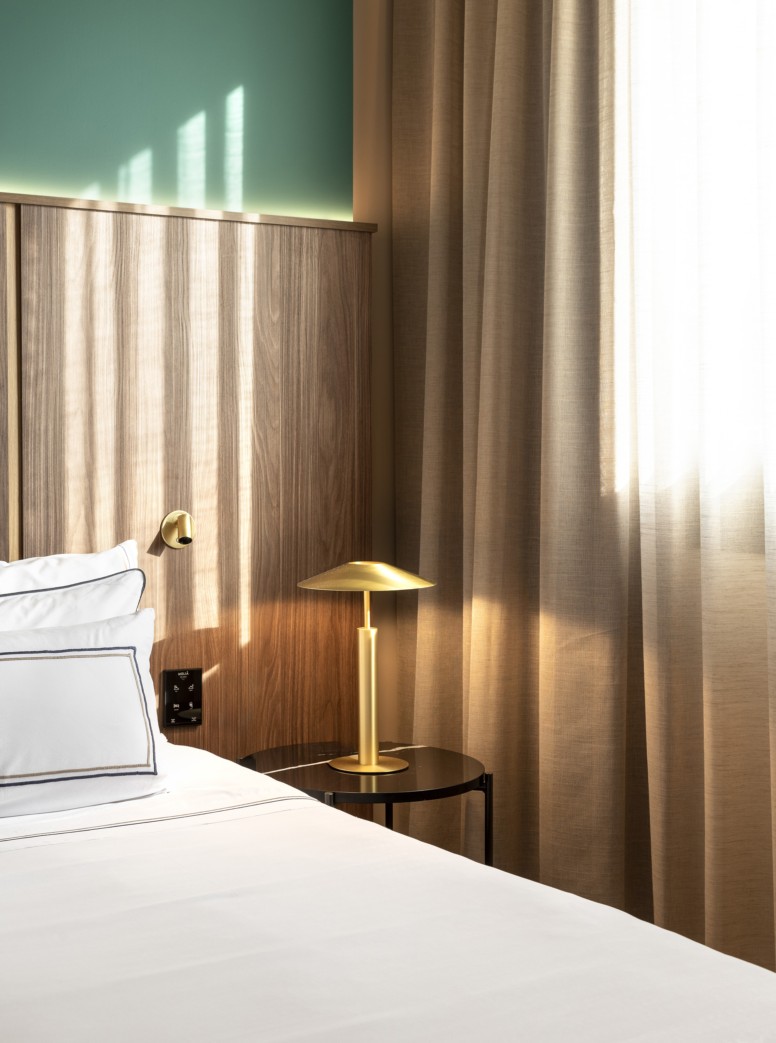 a bed with a lamp on a table