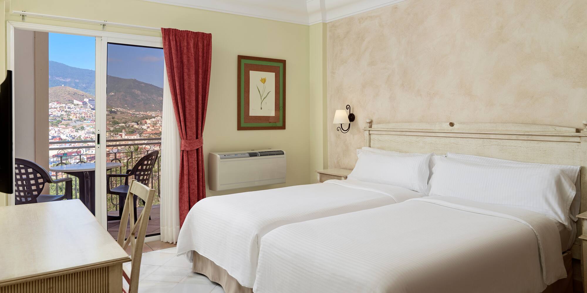 a room with two beds and a table and a balcony